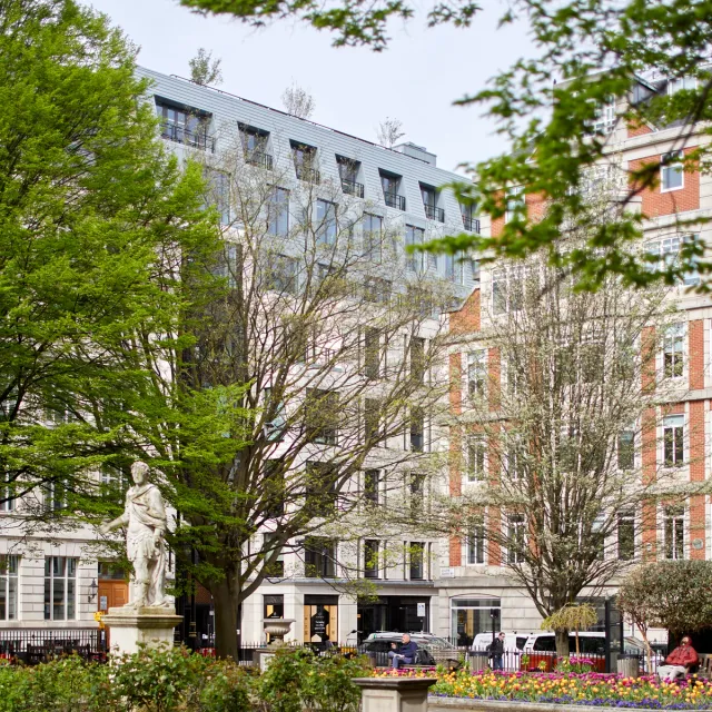 View of a tall office building across a landscaped square