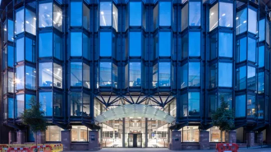 Glass building reflecting blue sky at dusk