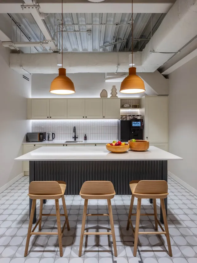 An office kitchenette with central island and tall stools