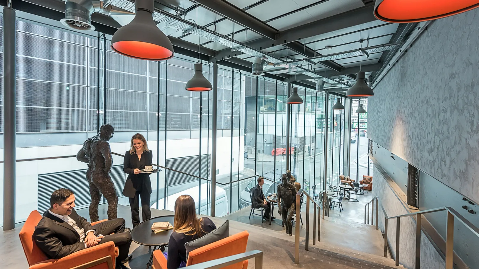interior with staris and people sitting on chairs. life size sculptures