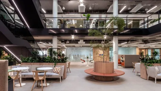 Interior view of atrium in modern office with communal seating area and indoor plants