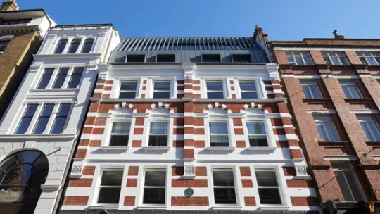 View looking up at red and white brick building facade