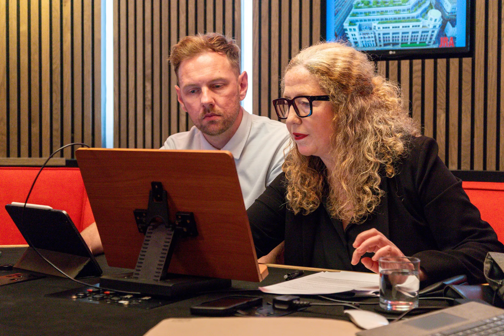 Close up of Andy and Etain on a laptop in a podcast studio