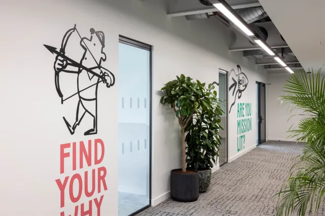 Motivational slogans on an office wall reading 'find your why' and 'are you mission lit?'