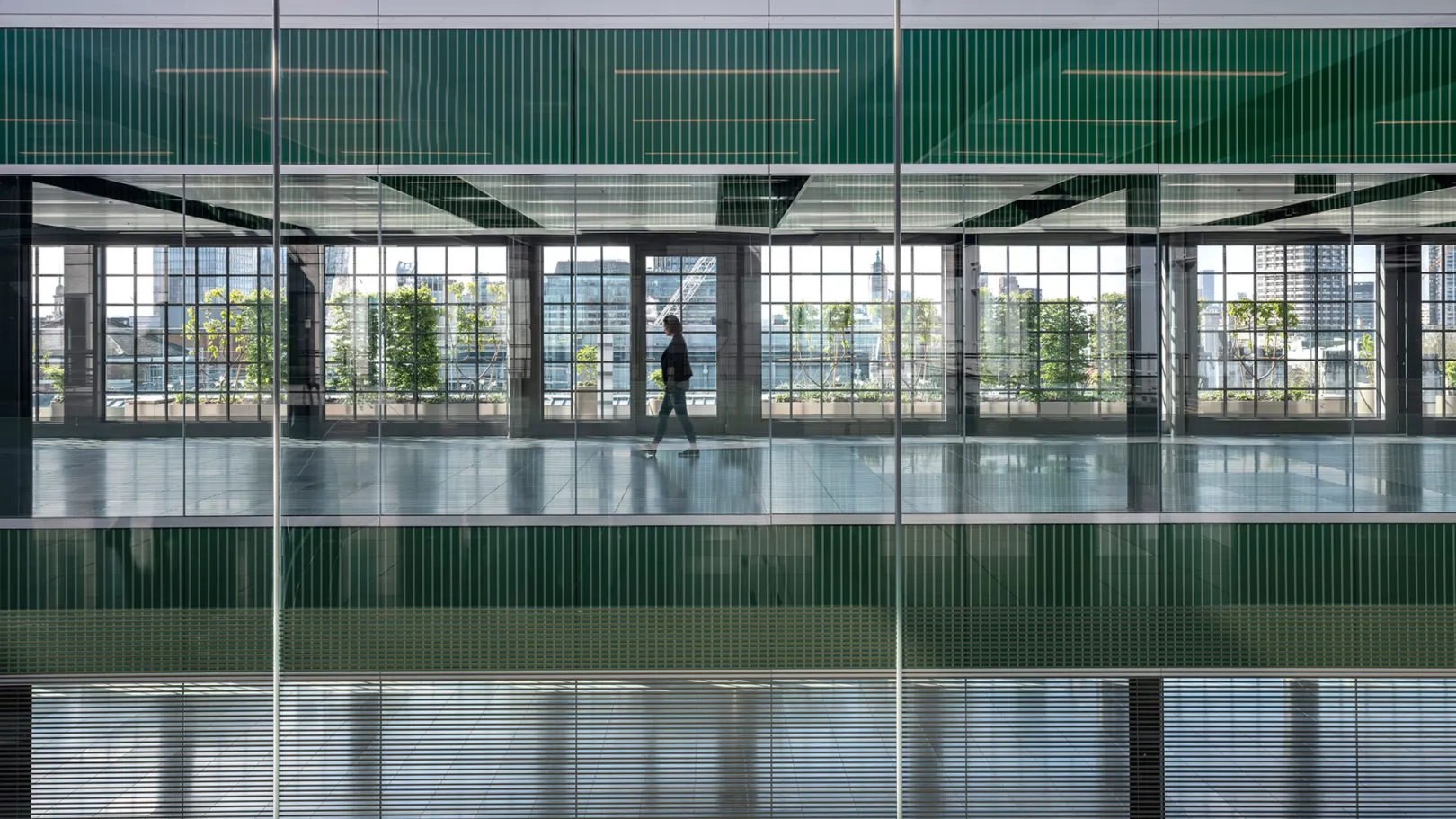 interior view of building with green atrium and person walking throuhg