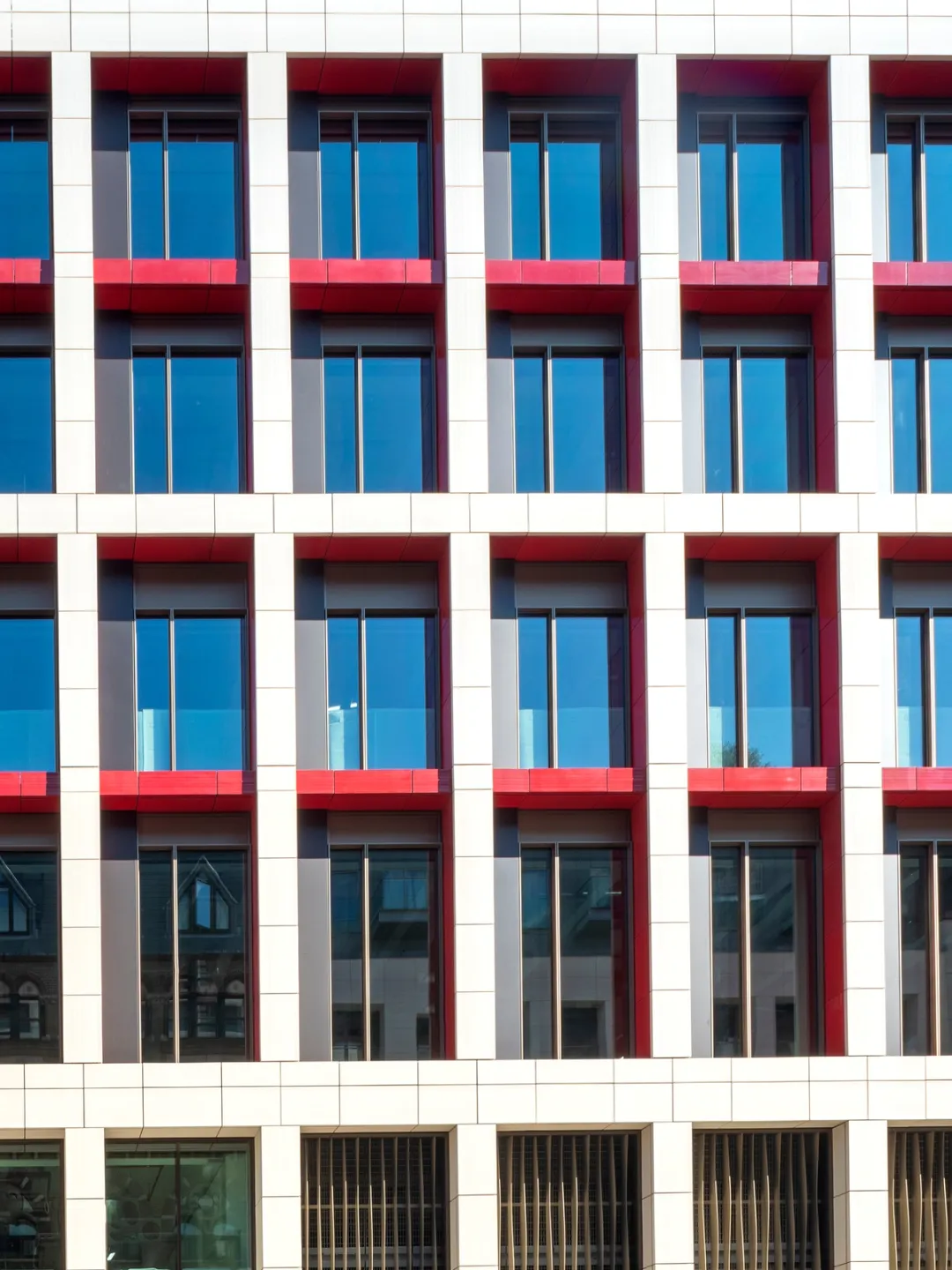 close up of building facade in red, white, red with windows