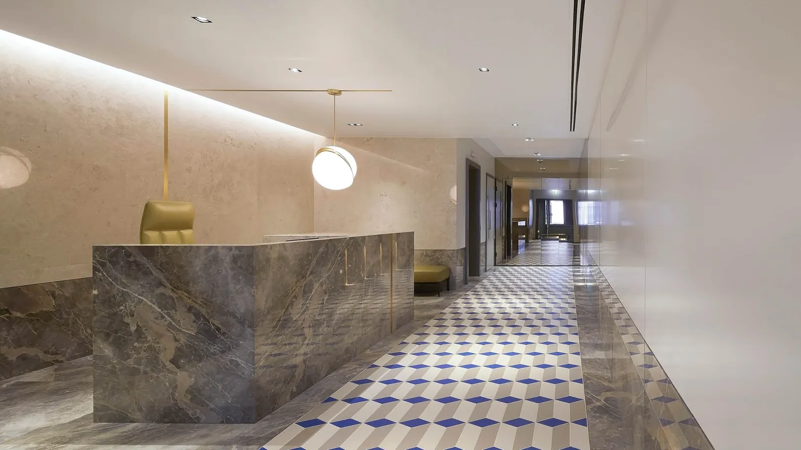 A reception hall with large marble reception desk and geometric tiled floor 