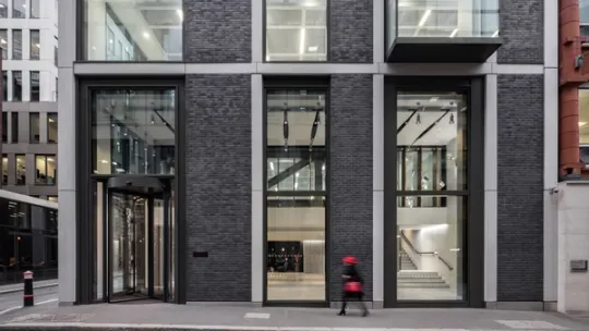 Street view of 90 Fetter Lane with woman walking past with red hat and red handbag