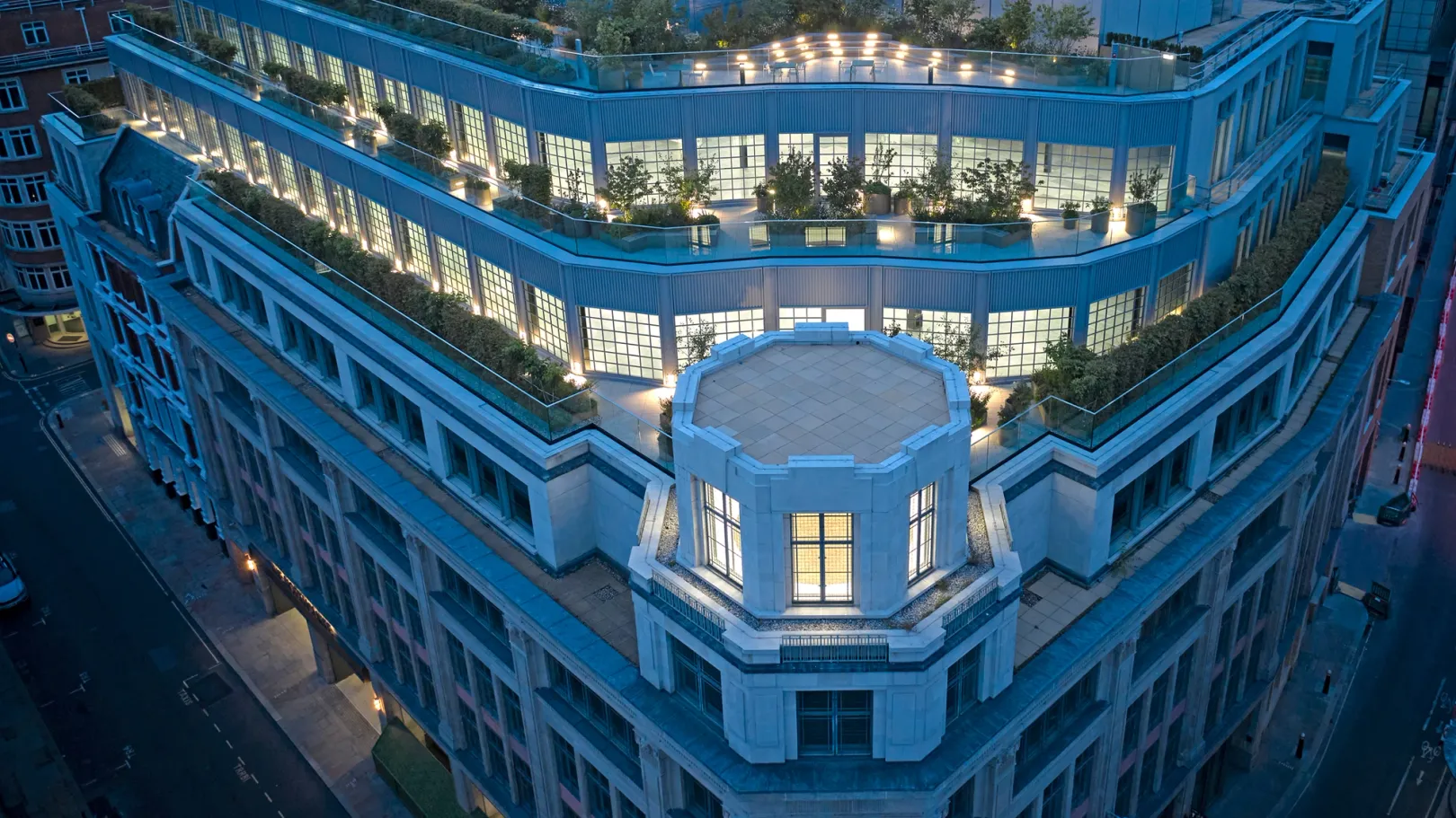 birds eye view of a building lit at dusk with blue colour