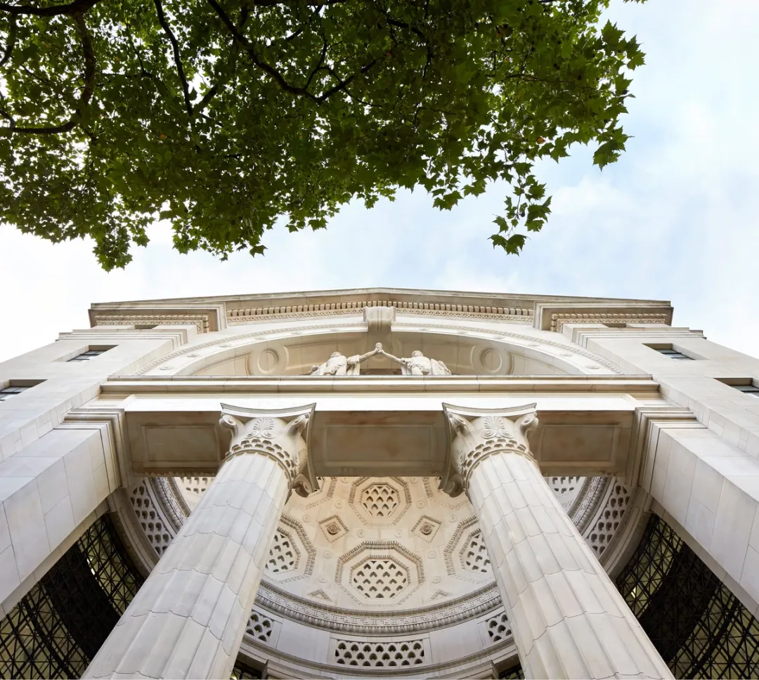image of historical building entrance with classical pillars and blue sky