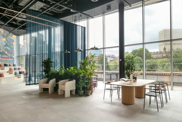 Double height lobby with seating, tables and city views