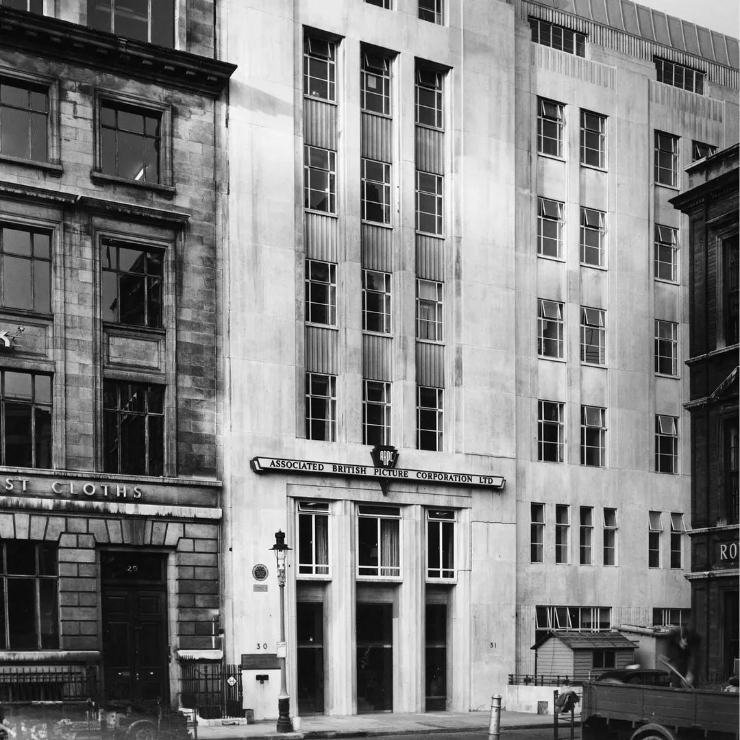 A black and white photo of a 1930s style office building 