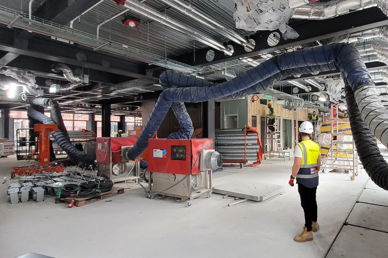 Tall triangular building with dome of cathedral in foreground