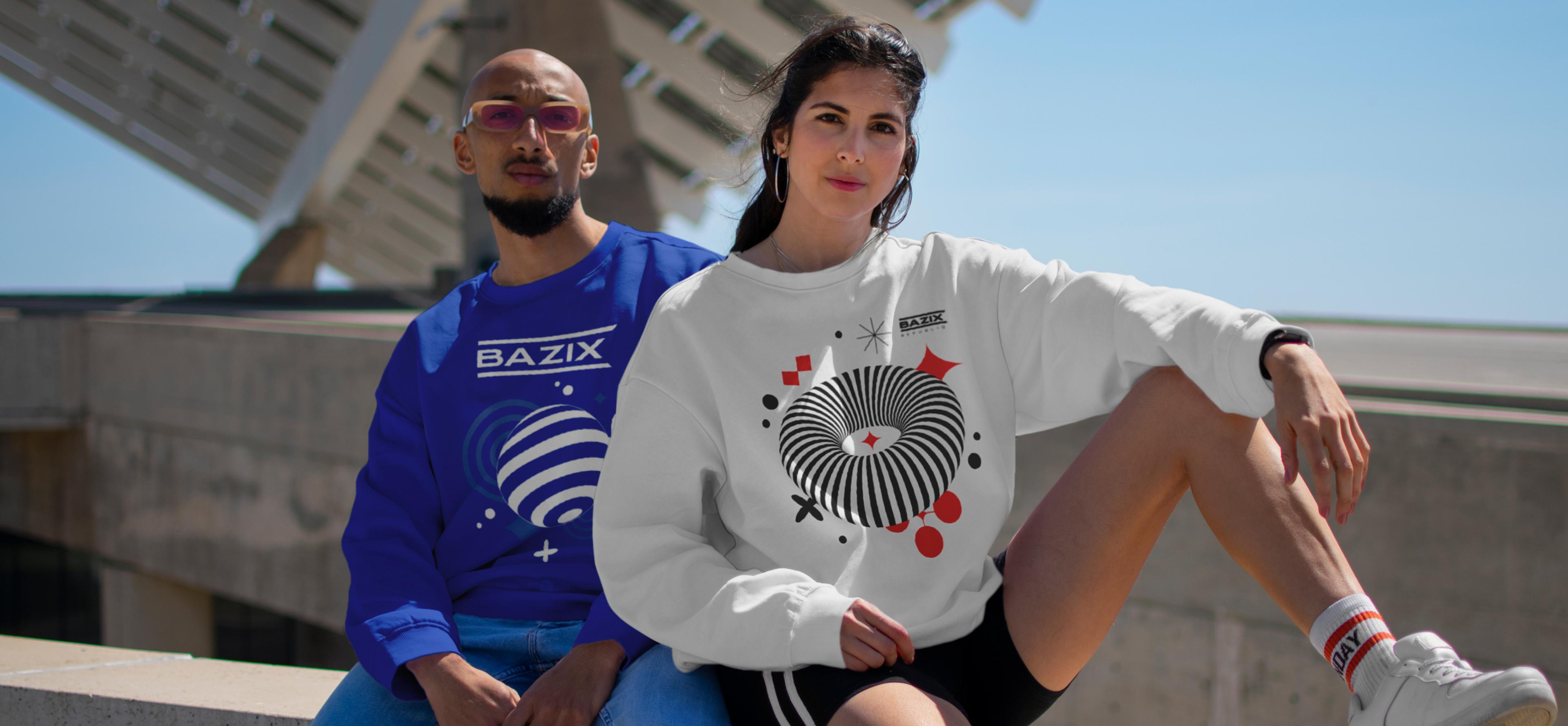 Mann und Frau in farblich abgestimmten Streetwear-Sweatern mit futuristischem Design und Bazix-Branding, posierend vor moderner Architektur. Boldes, mänliches, modernes Design. Gen Z Stil.
