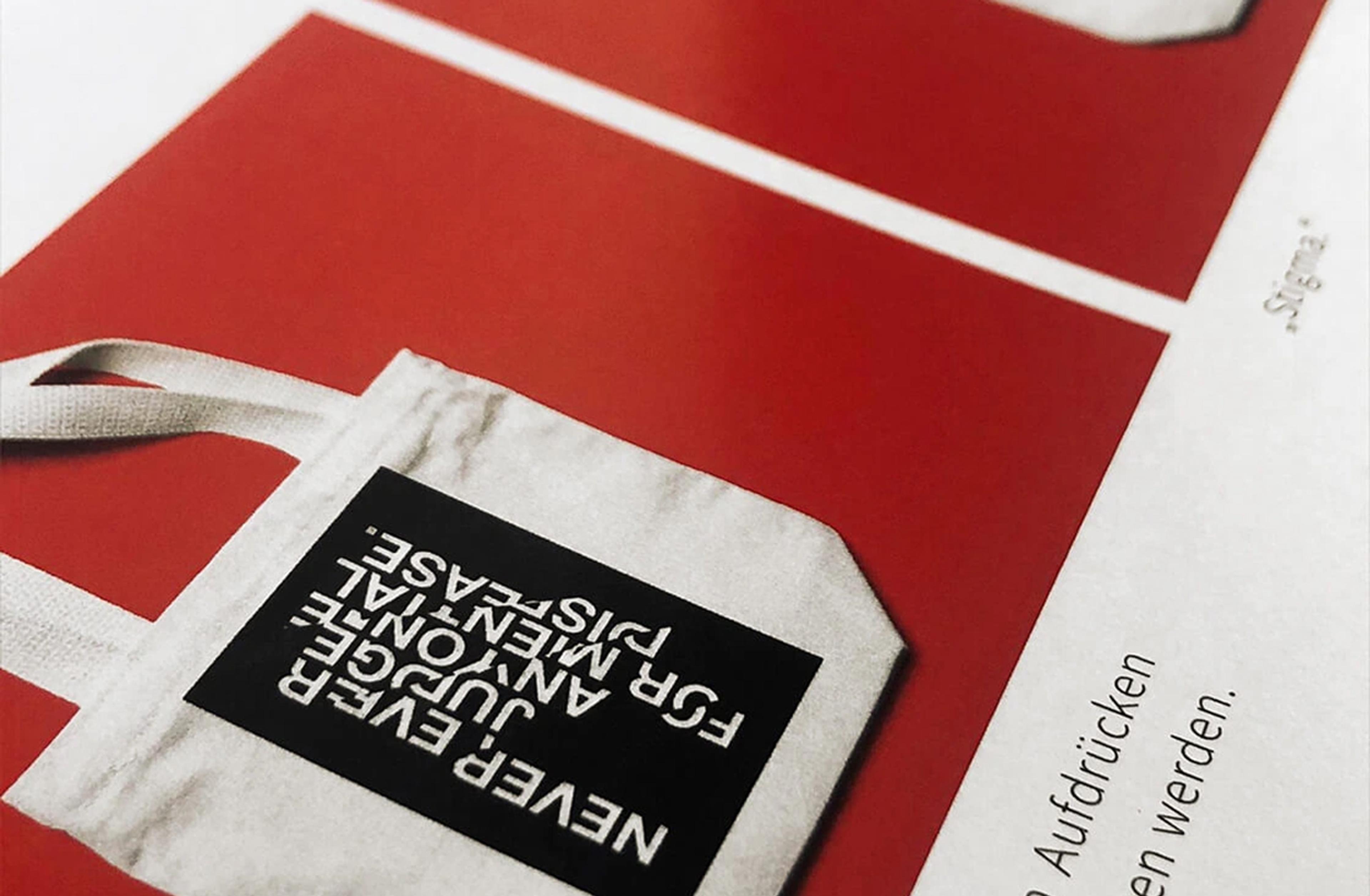 Ein weißer Stoffbeutel mit schwarzem Print liegt auf rotem Hintergrund. Der Text „NEVER EVER JUDGE ANYONE FOR A MENTAL DISEASE“ setzt ein klares Statement gegen Vorurteile gegenüber psychischen Erkrankungen.