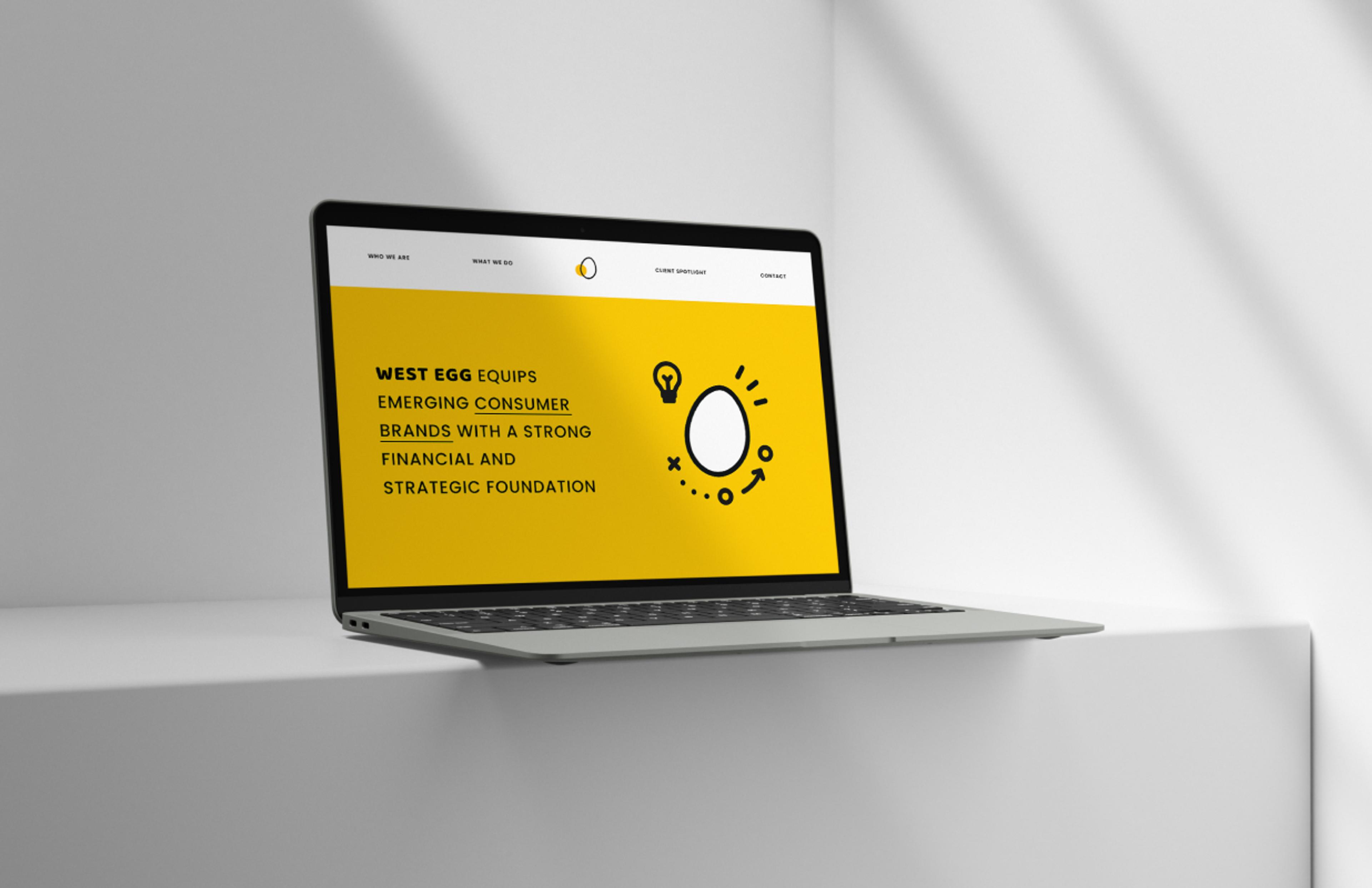 Laptop mit West Egg Consulting Website auf weißer Oberfläche – Ein moderner Laptop zeigt die West Egg Consulting Website mit gelbem Hintergrund, schwarzem Text und einer illustrierten Ei-Grafik. Die Website betont Finanz- und Strategieexpertise für Marken.