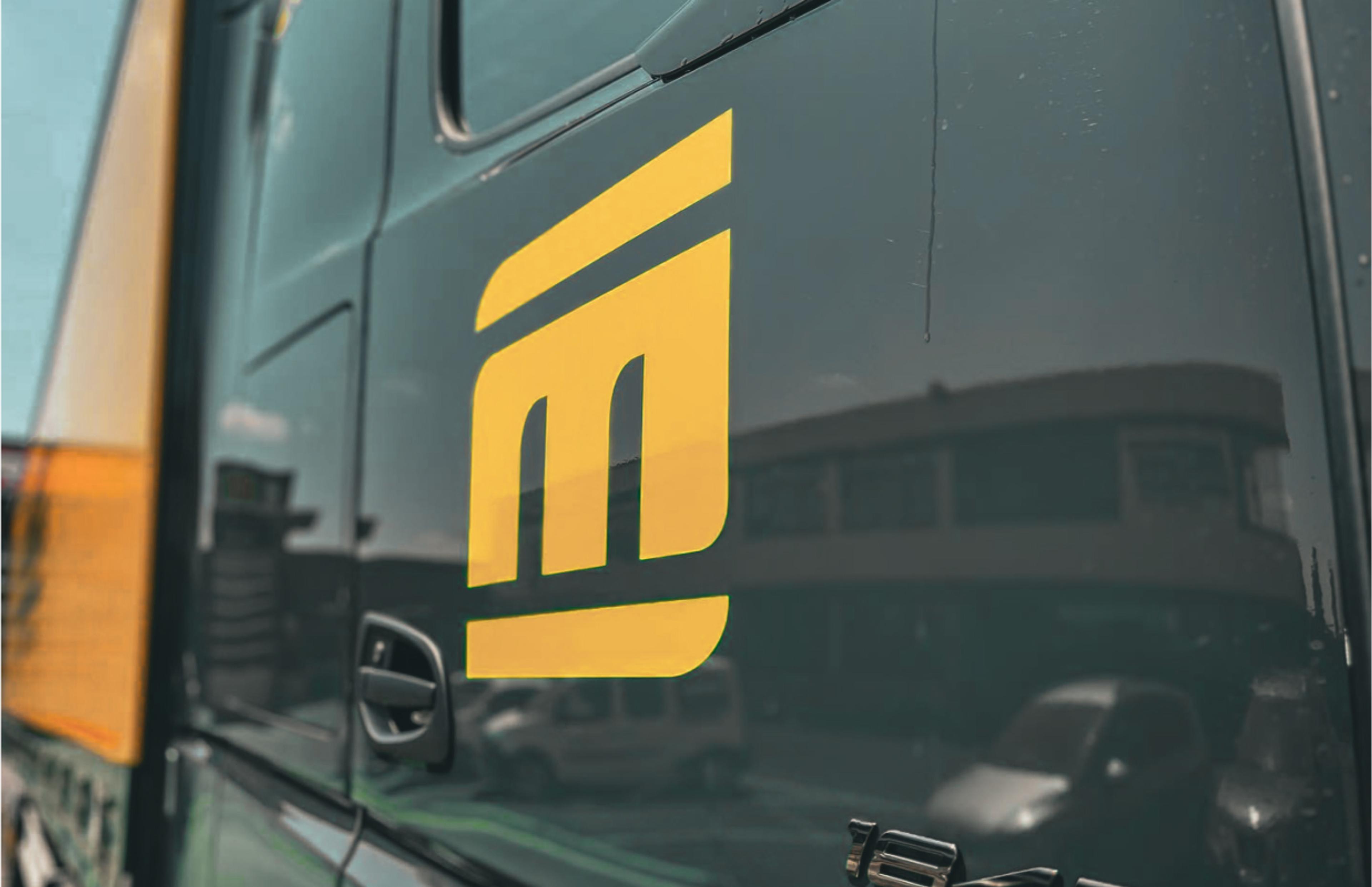 Gebrandete LKW-Flotte von Michel Logistik, gestaltet von Unerwartet Design. Die Fahrzeuge präsentieren das neue Michel-Logo in Grün und Weiß für eine einheitliche Markenpräsenz.