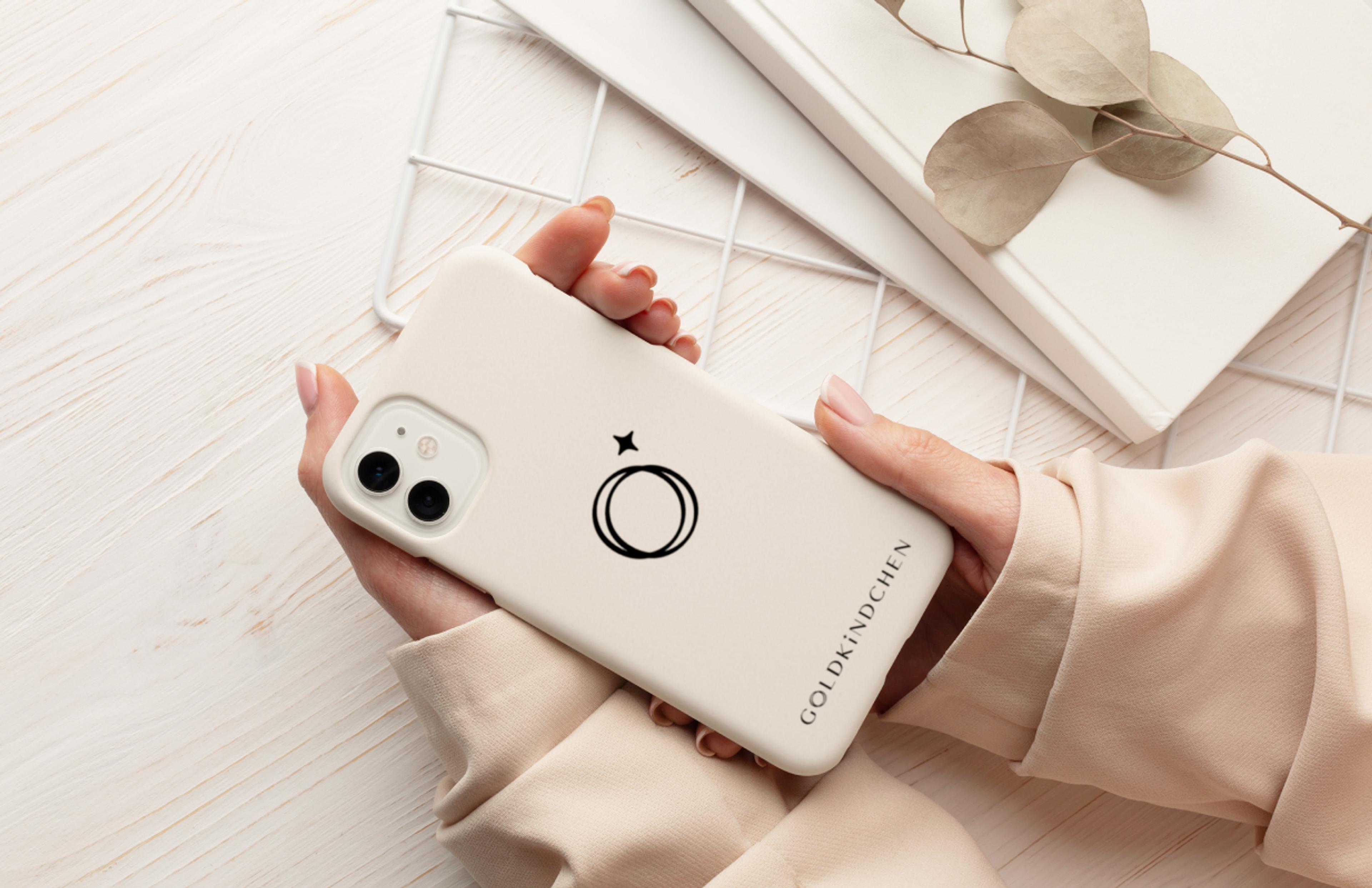 Branding in jeder Dimension: Das neue Goldkindchen Logo auf einer Smartphone-Hülle symbolisiert den Lifestyle-Gedanken der Marke. Corporate Design, das überall funktioniert.