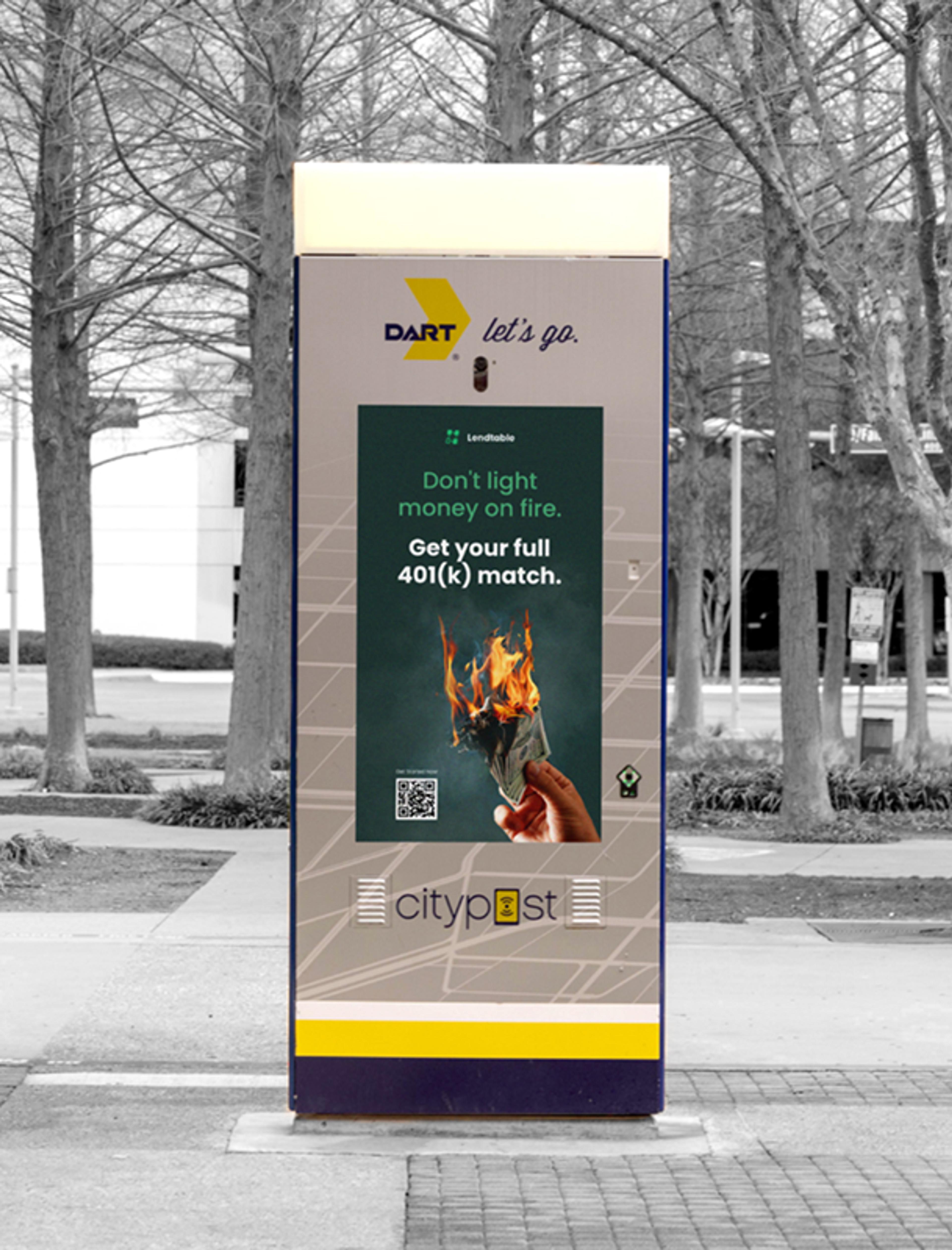 Digitale Werbeanzeige von Lendtable auf einem Terminal in einer belebten Stadtumgebung mit kahlen Bäumen im Hintergrund.