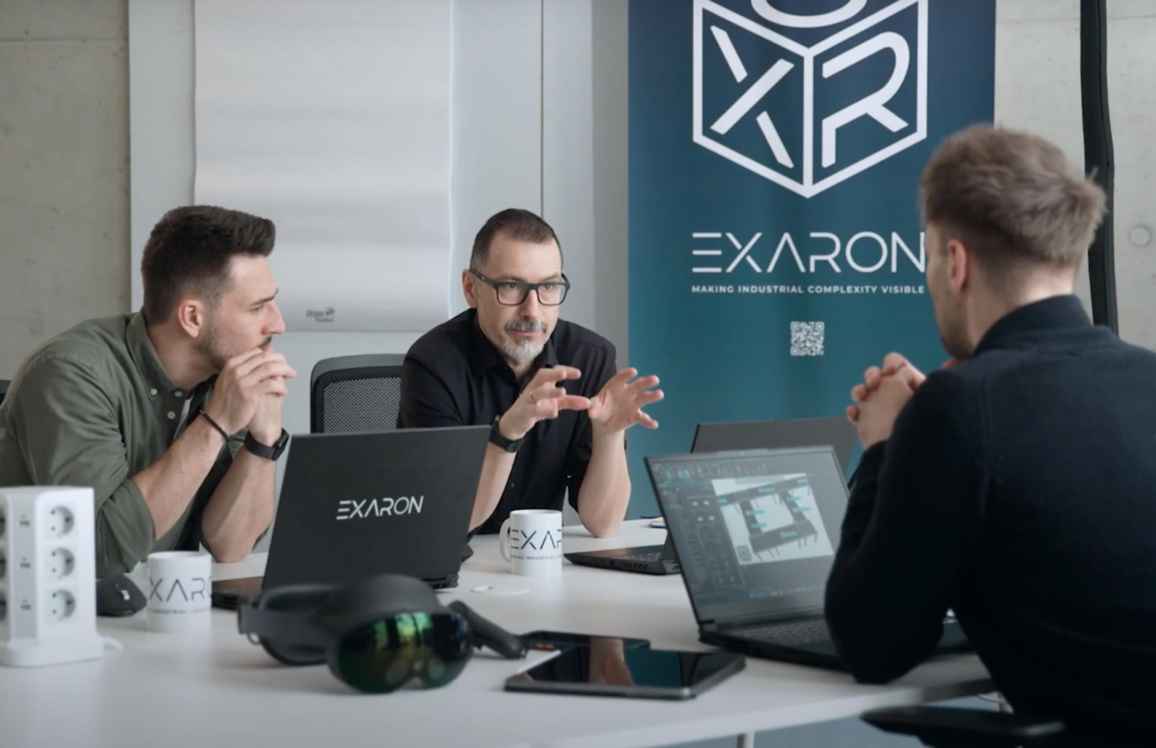 EXARON GmbH Business-Meeting bei Exaron mit Branding-Elementen, gestaltet von Unerwartet Design, die die technologische Vision des Unternehmens unterstreichen.