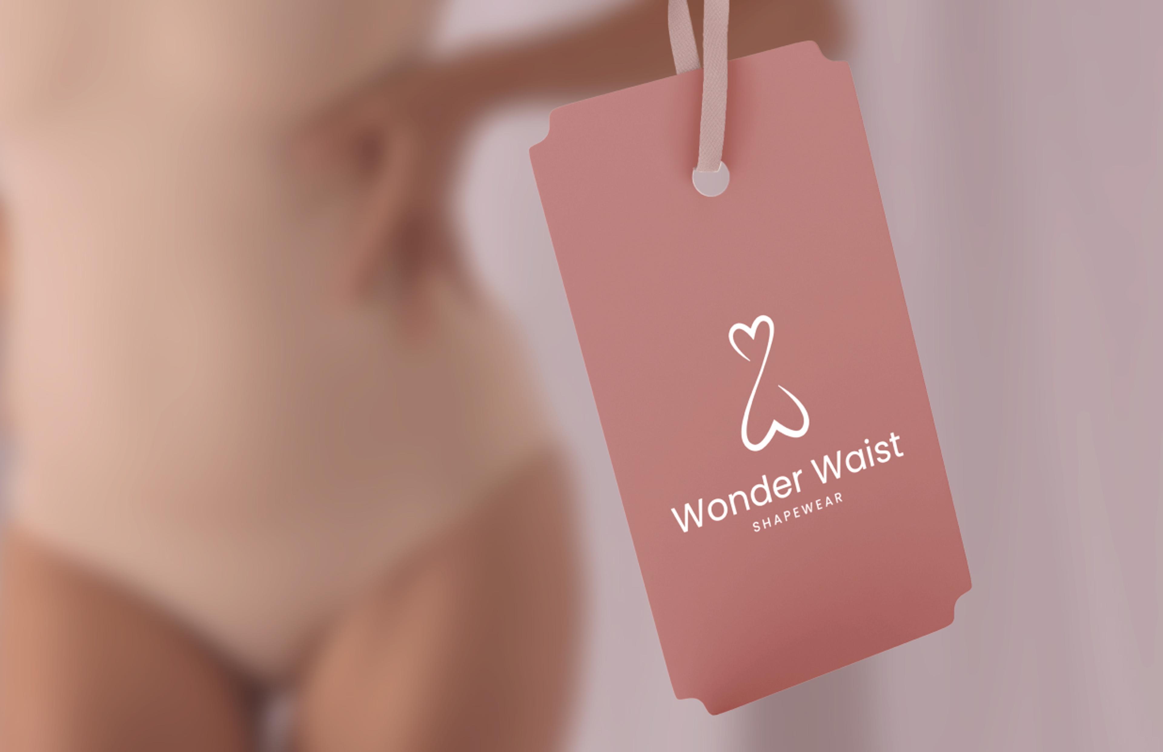 Produktanhänger von Wonder Waist in Rosé-Ton – Ein rosafarbener Anhänger mit Wonder Waist Logo und Branding, gehalten von einem Band. Im unscharfen Hintergrund ist eine Frau in hautfarbener Shapewear zu sehen.Produktanhänger von Wonder Waist in Rosé-Ton – Ein rosafarbener Anhänger mit Wonder Waist Logo und Branding, gehalten von einem Band. Im unscharfen Hintergrund ist eine Frau in hautfarbener Shapewear zu sehen.