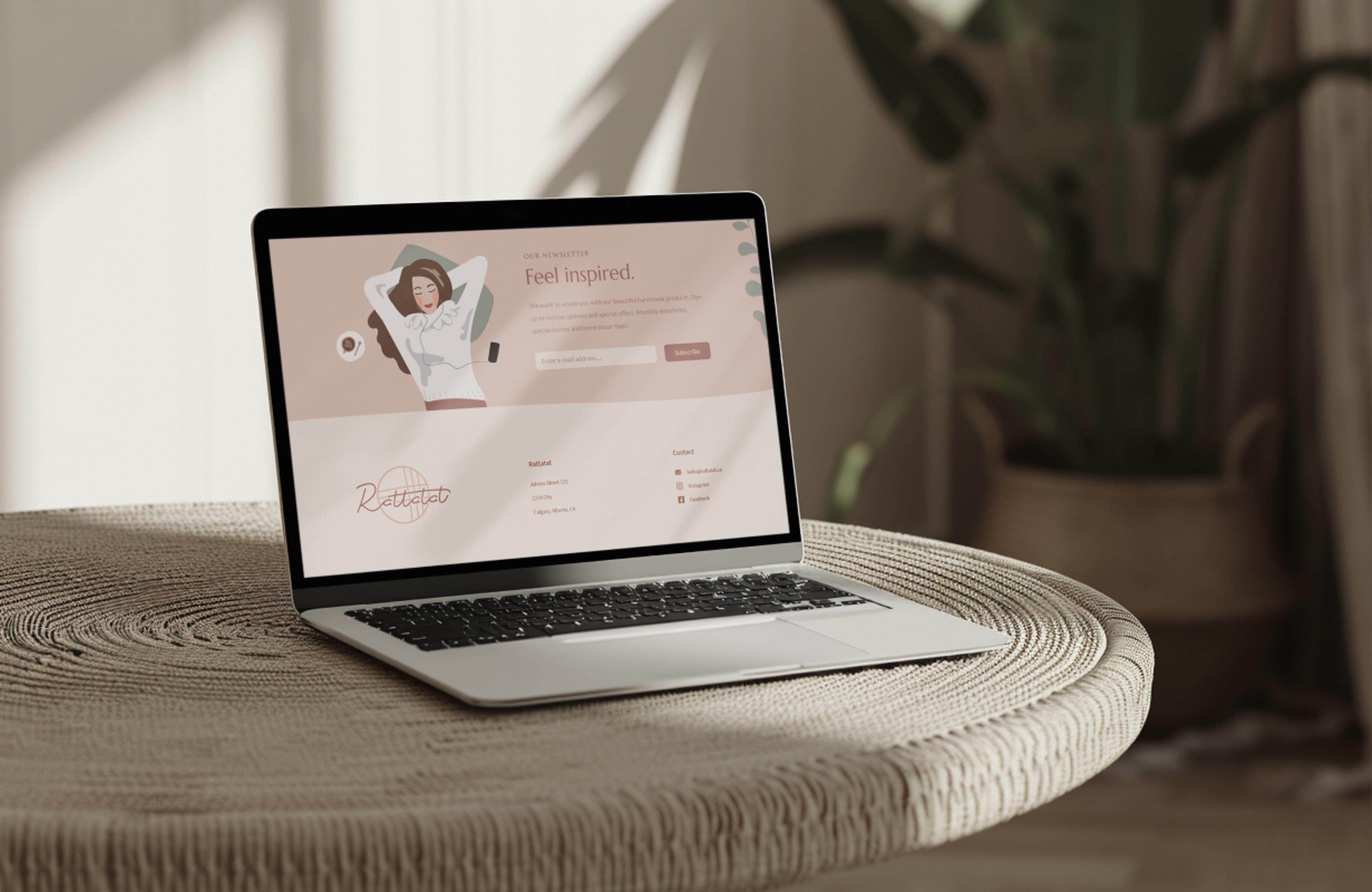 Laptop auf einem runden Rattan-Tisch in natürlichem Licht mit der Newsletter-Seite von Rattatat. Stilvolle und benutzerfreundliche Website, die eine warme und einladende Atmosphäre schafft, entworfen von Unerwartet Design in Graz.