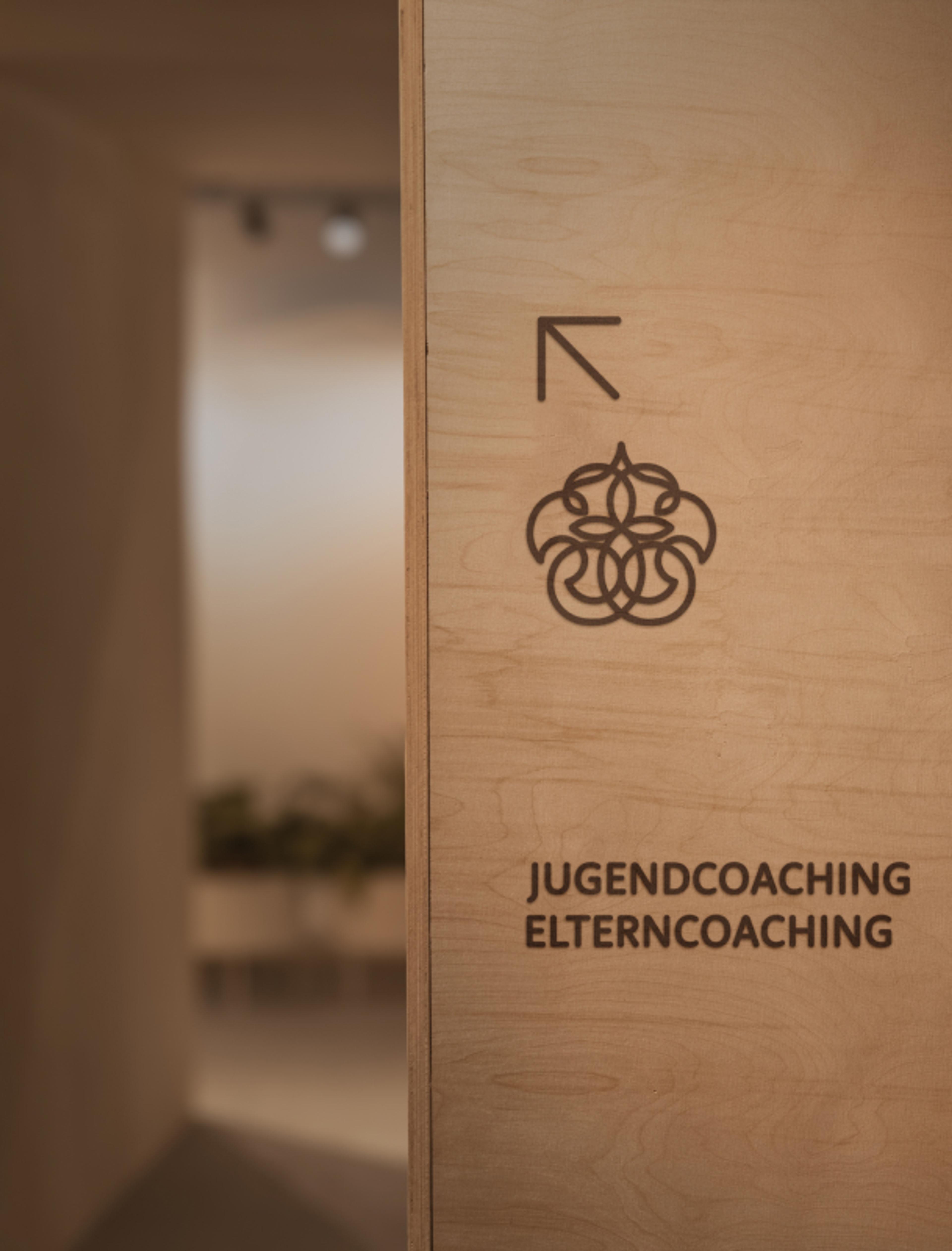 Beschilderung für Jugendcoaching und Elterncoaching mit Logo von Kunter Bunter Weg. Modernes Raumdesign, realisiert von Unerwartet Design Graz.