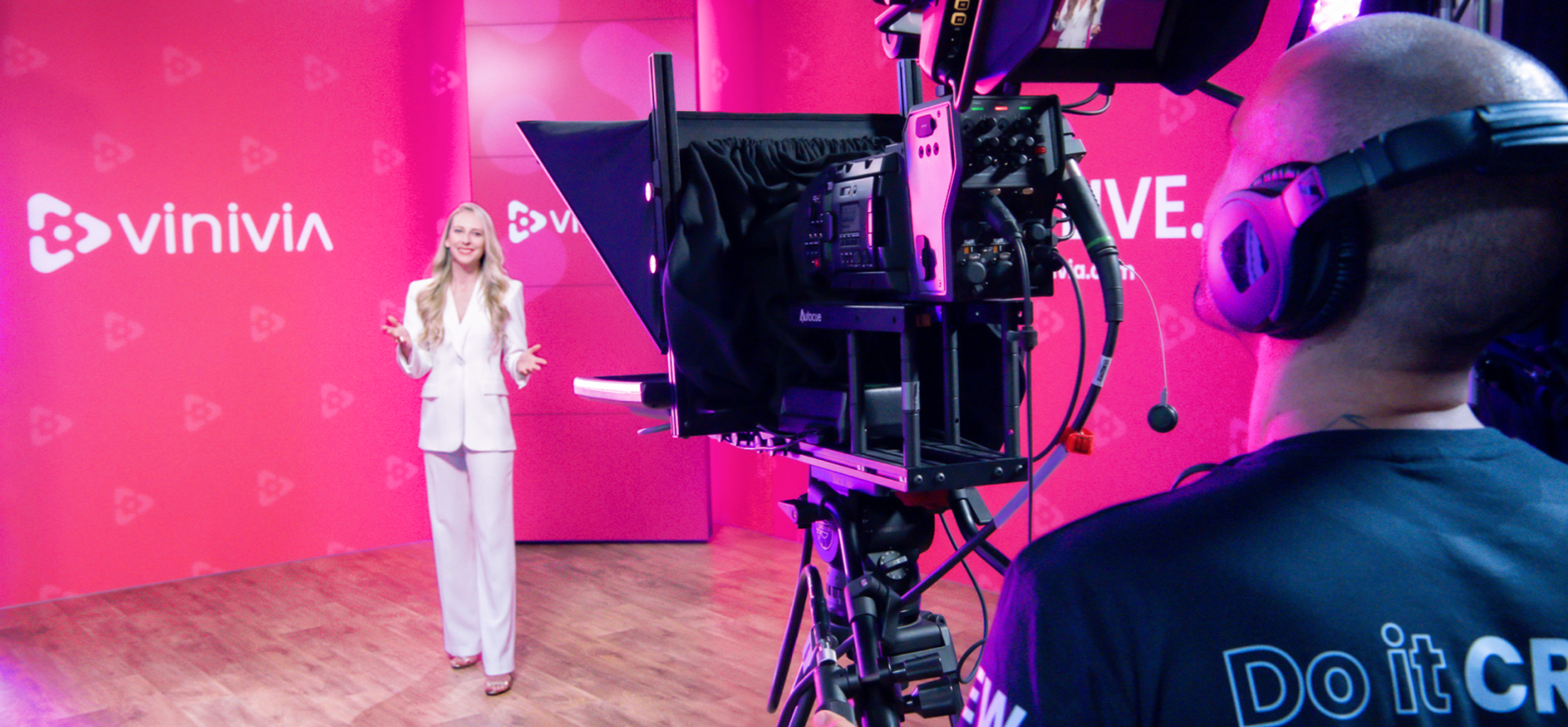 vinivia Professionelle Aufnahme eines Live-Streaming-Events bei Vinivia, moderiert von einer eleganten Gastgeberin vor einer markanten pinken Hintergrundwand – Unerwartet Design