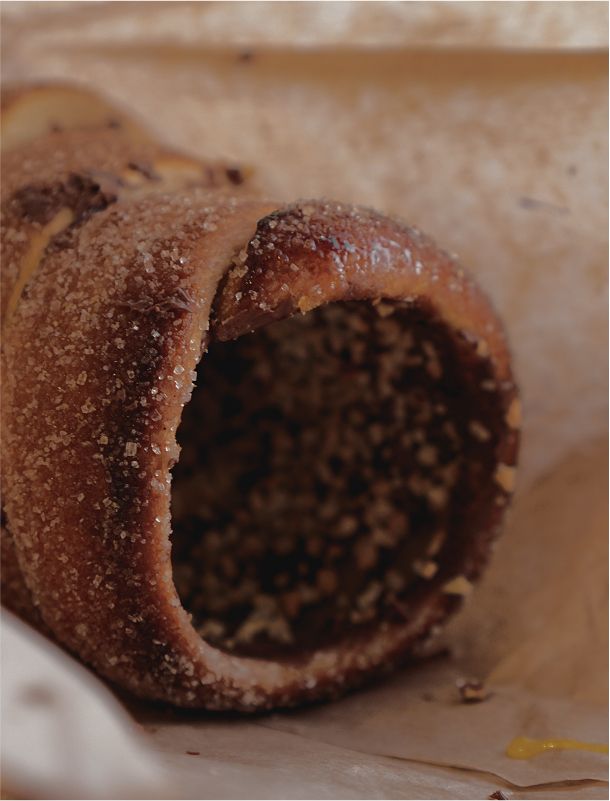 Nahaufnahme eines karamellisierten Baumkuchens mit Zuckerkruste und gehackten Nüssen.