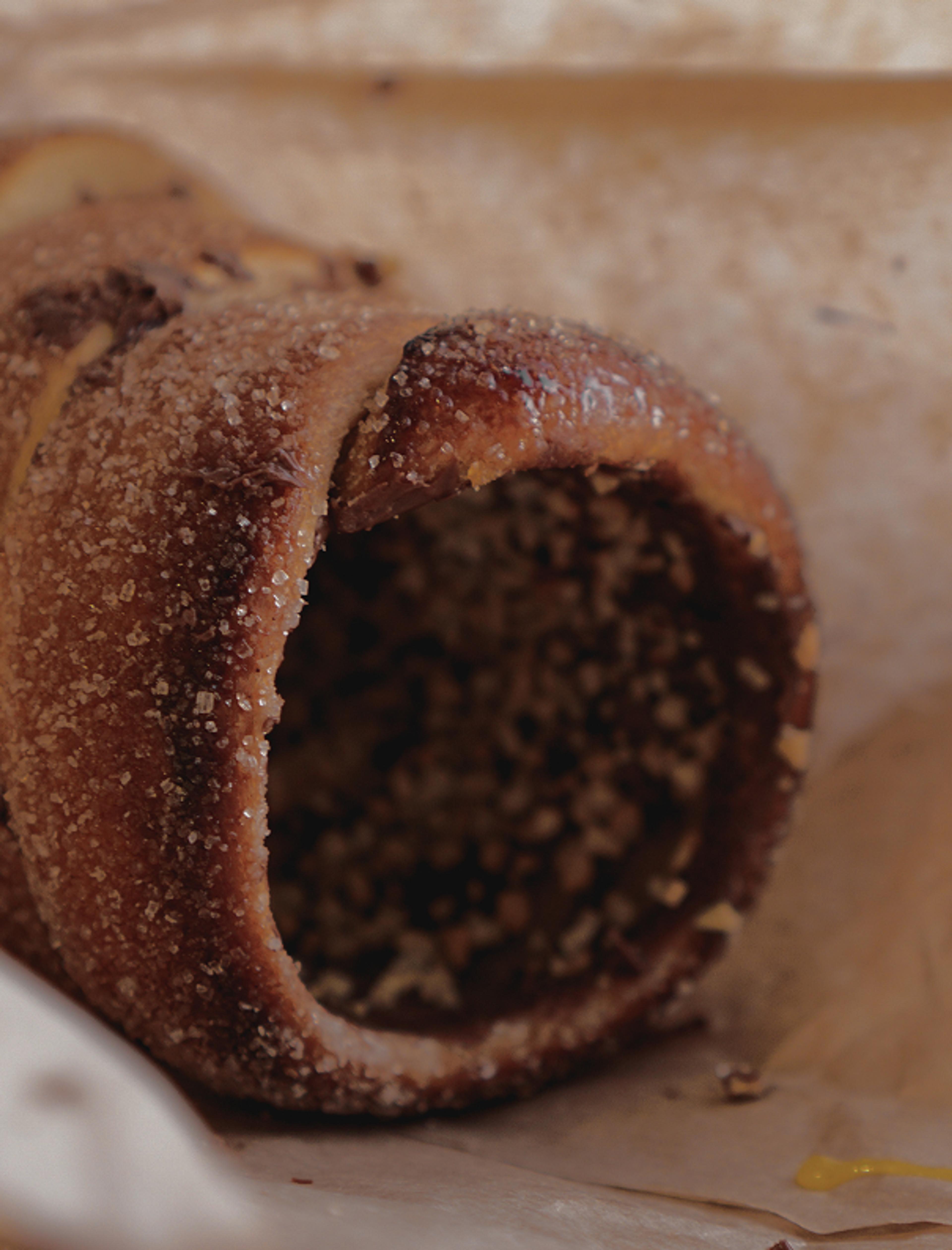 Nahaufnahme eines karamellisierten Baumkuchens mit Zuckerkruste und gehackten Nüssen.