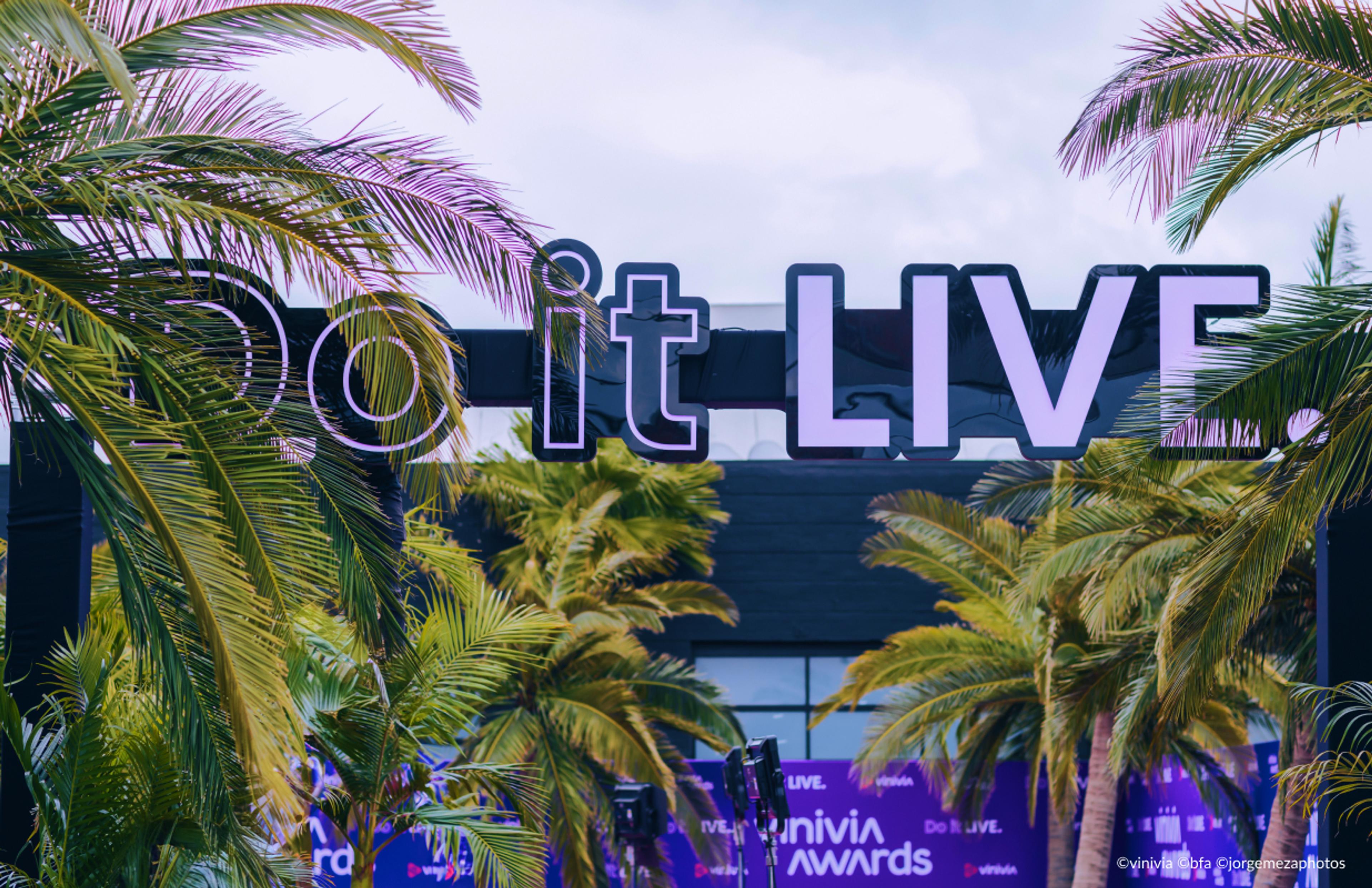 vinivia, bfa, jorgemezaphotos Vinivia Awards Event: Großes 'Do it LIVE' Schild in modernem Design zwischen Palmen, violette Event-Branding-Elemente im Hintergrund – Unerwartet Design