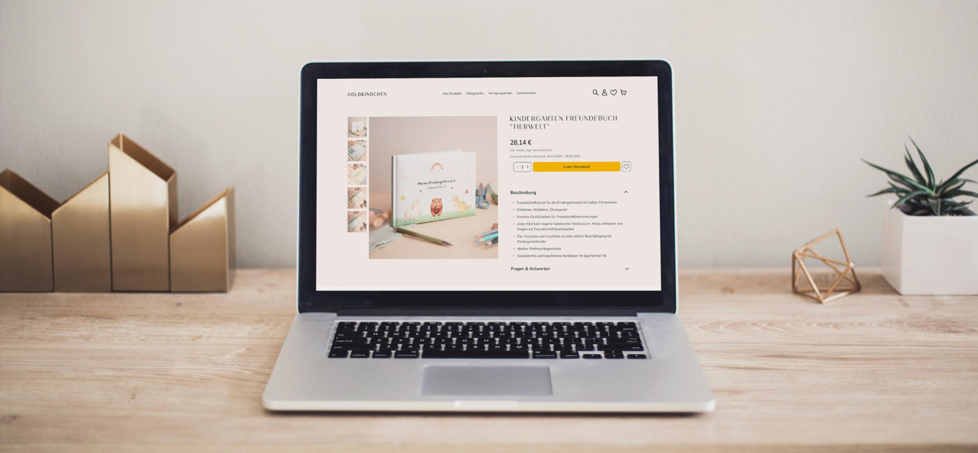 Goldkindchen-Webshop auf einem Laptop mit einer Produktseite für das Kindergarten-Freundebuch und Kaufoptionen.