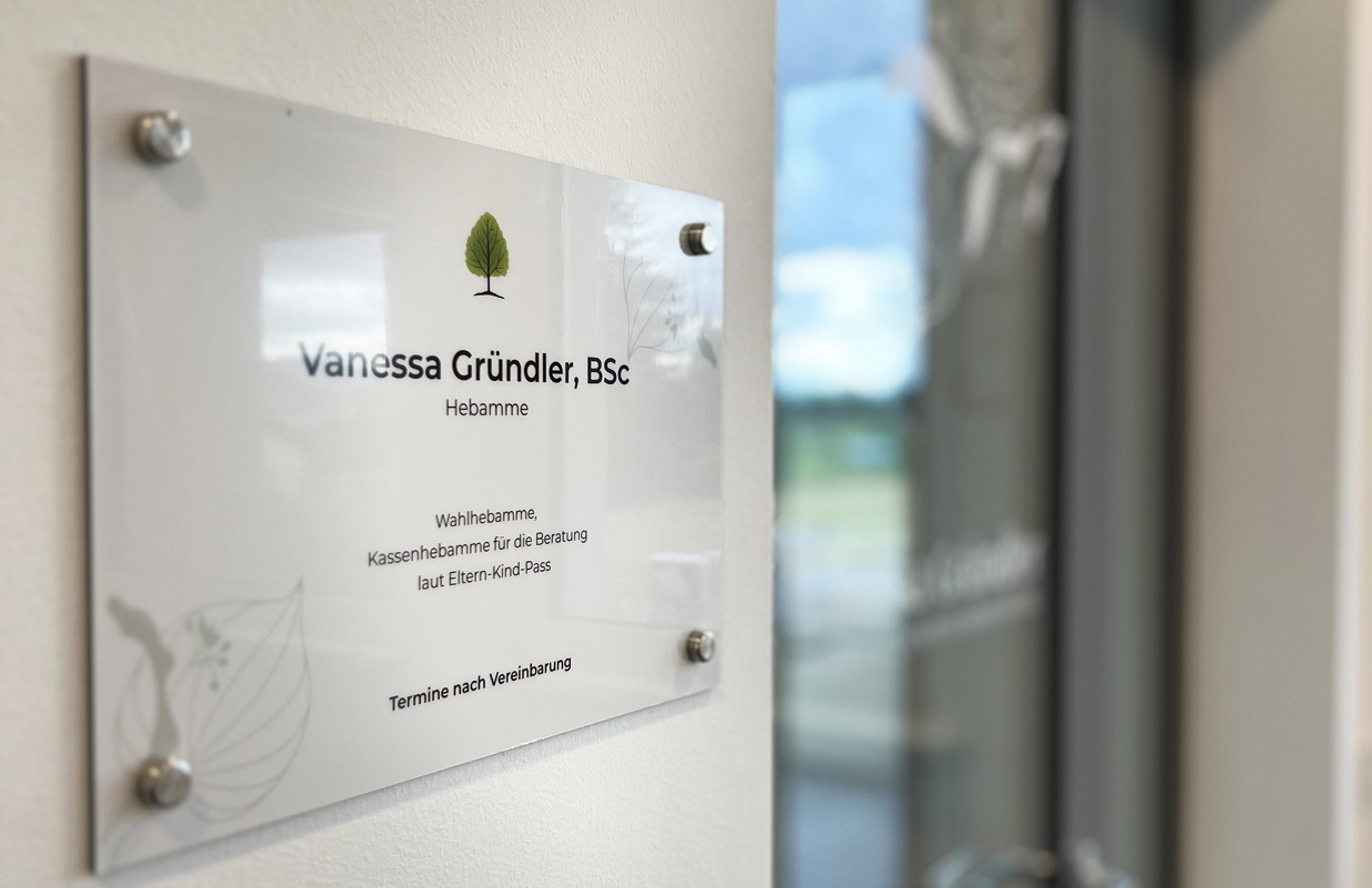 Acrylschild mit Branding für Hebamme Vanessa Gründler. Schlichte, natürliche Gestaltung mit sanften Farben und organischen Elementen. Design von Unerwartet Design.