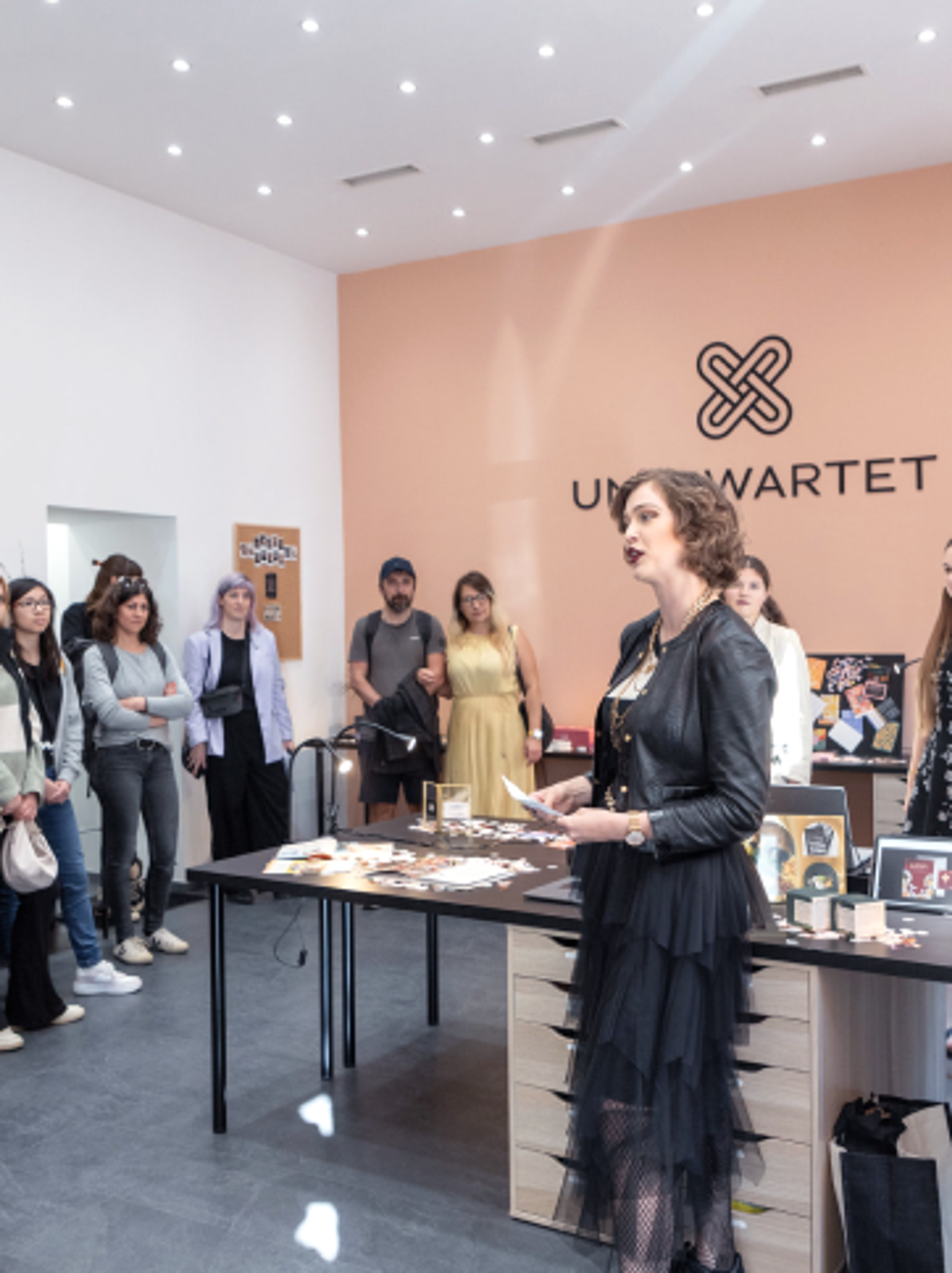 Beatrice Siegl erzählt die Unerwartet Design Geschichte unsere Projekte vor einem großen Publikum in der Creative Night im Jahr 2023. Ausstellung in Unerwartet Design Büro in der Belgiergasse 16, im Herzen von Graz. Studentinnen aus der FH Joanneum, Studiengang Informationsdesign schauen zu. Eine Initiative der Creative Industries Styria.