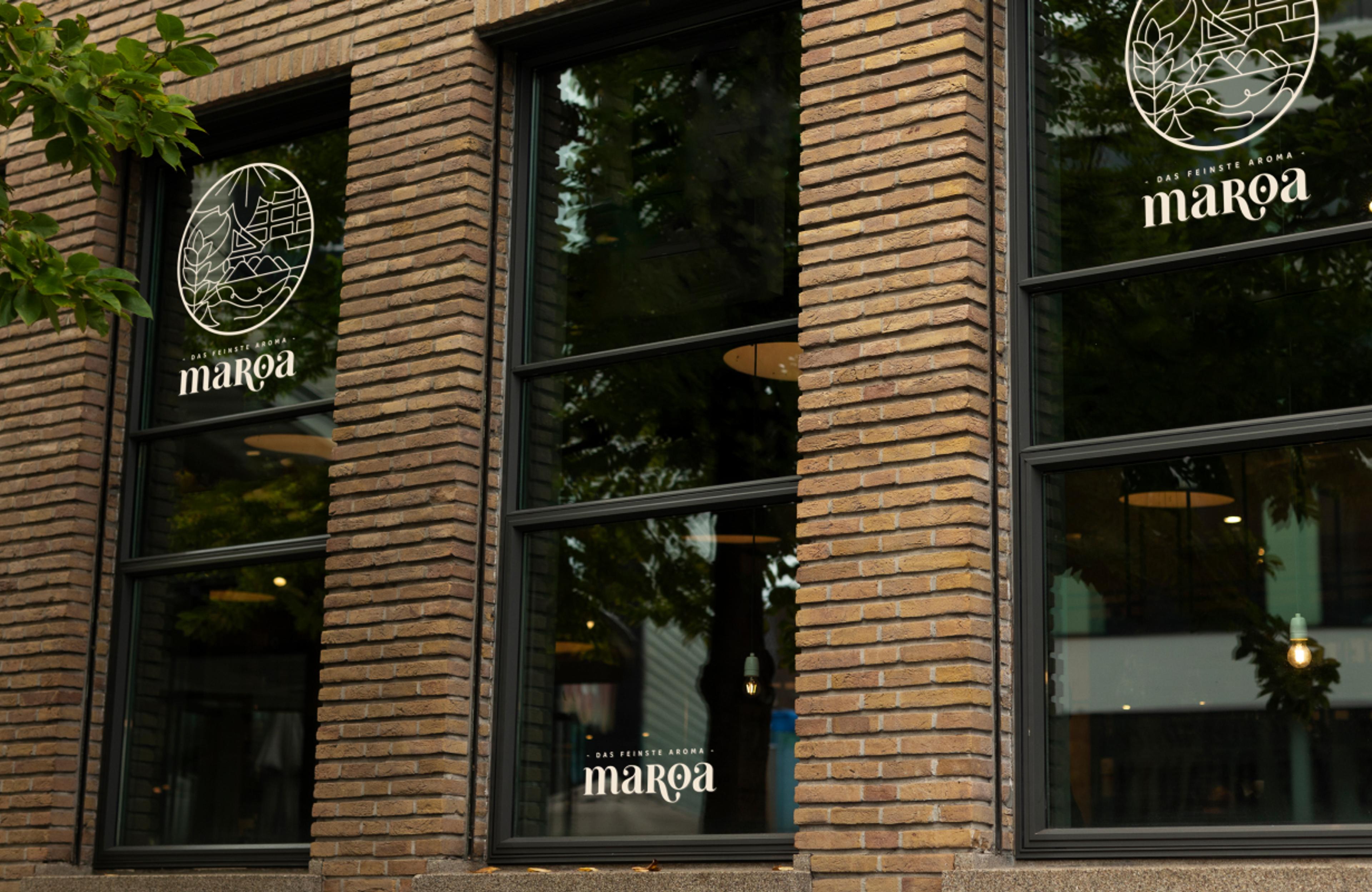 Maroa-Logo auf einer Fensterfront, Teil des Corporate Designs von Unerwartet Design.