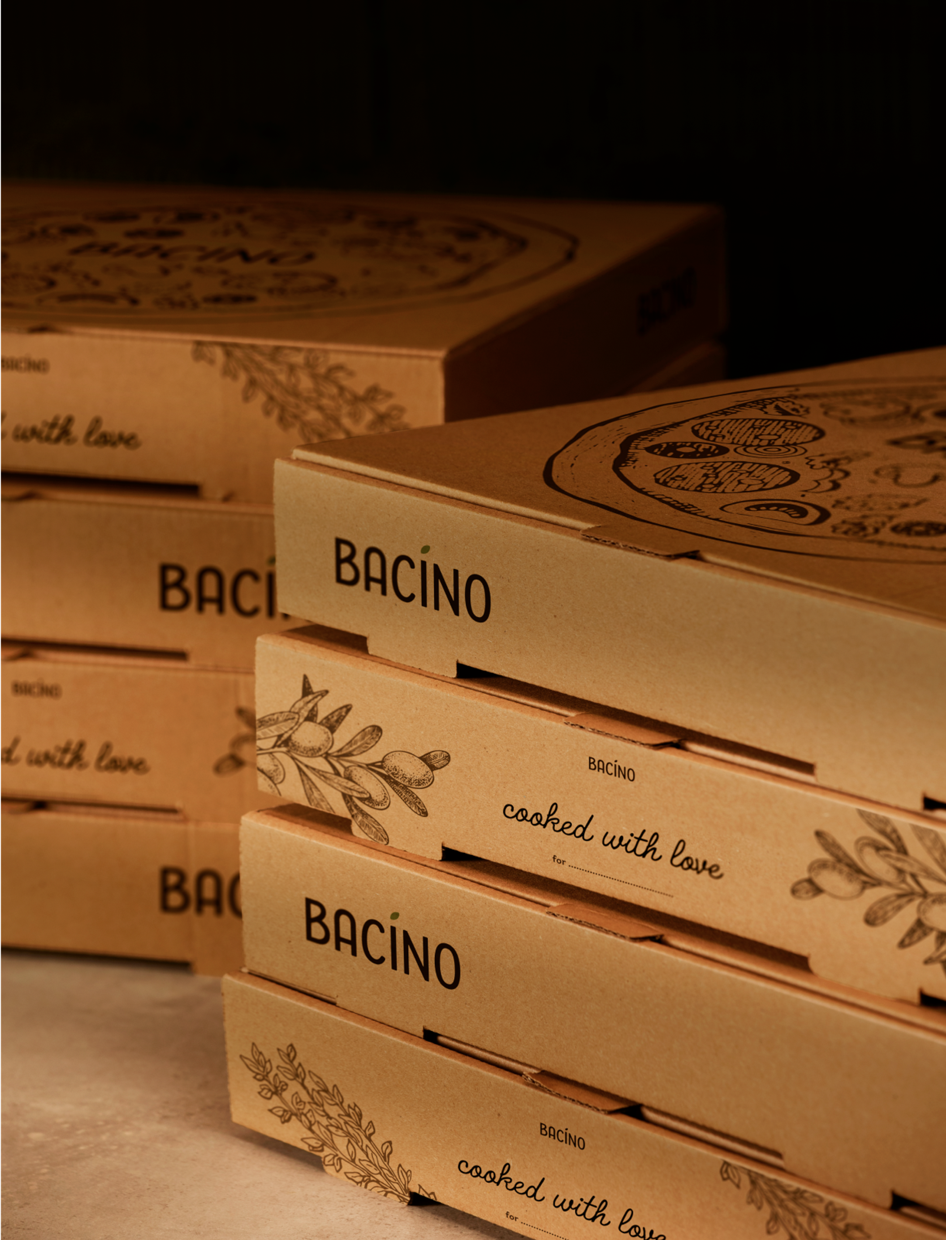 Gestapelte Pizzakartons von Bacino mit mediterranen Illustrationen und dem Schriftzug 'Cooked with love'