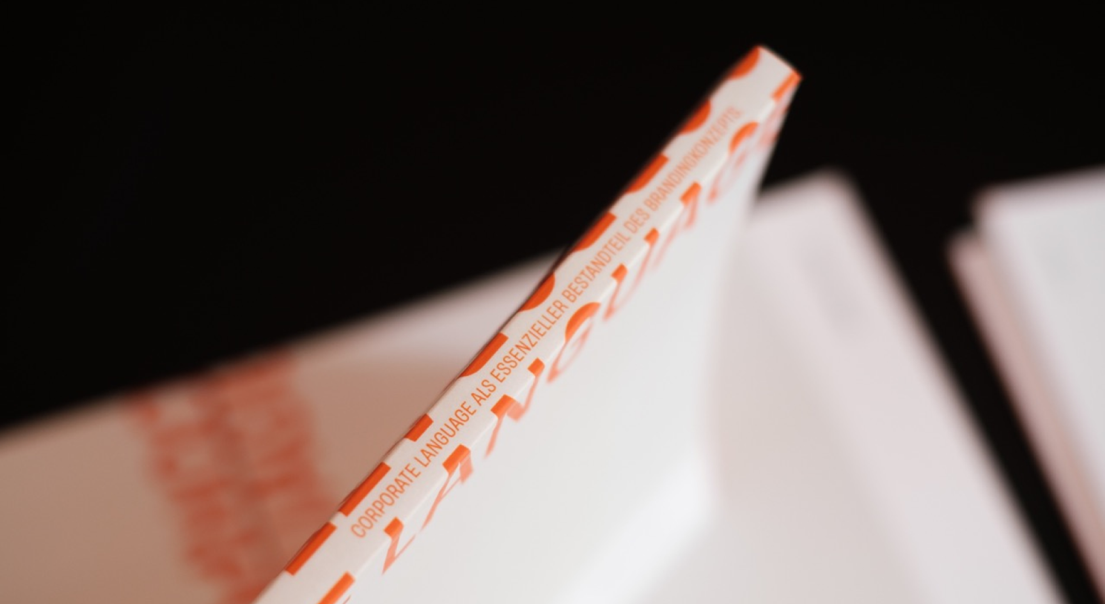 Rückseite des Corporate Language Leitfadens von Valerie Zengerer und Unerwartet Design, mit schmaler orangefarbener Beschriftung.