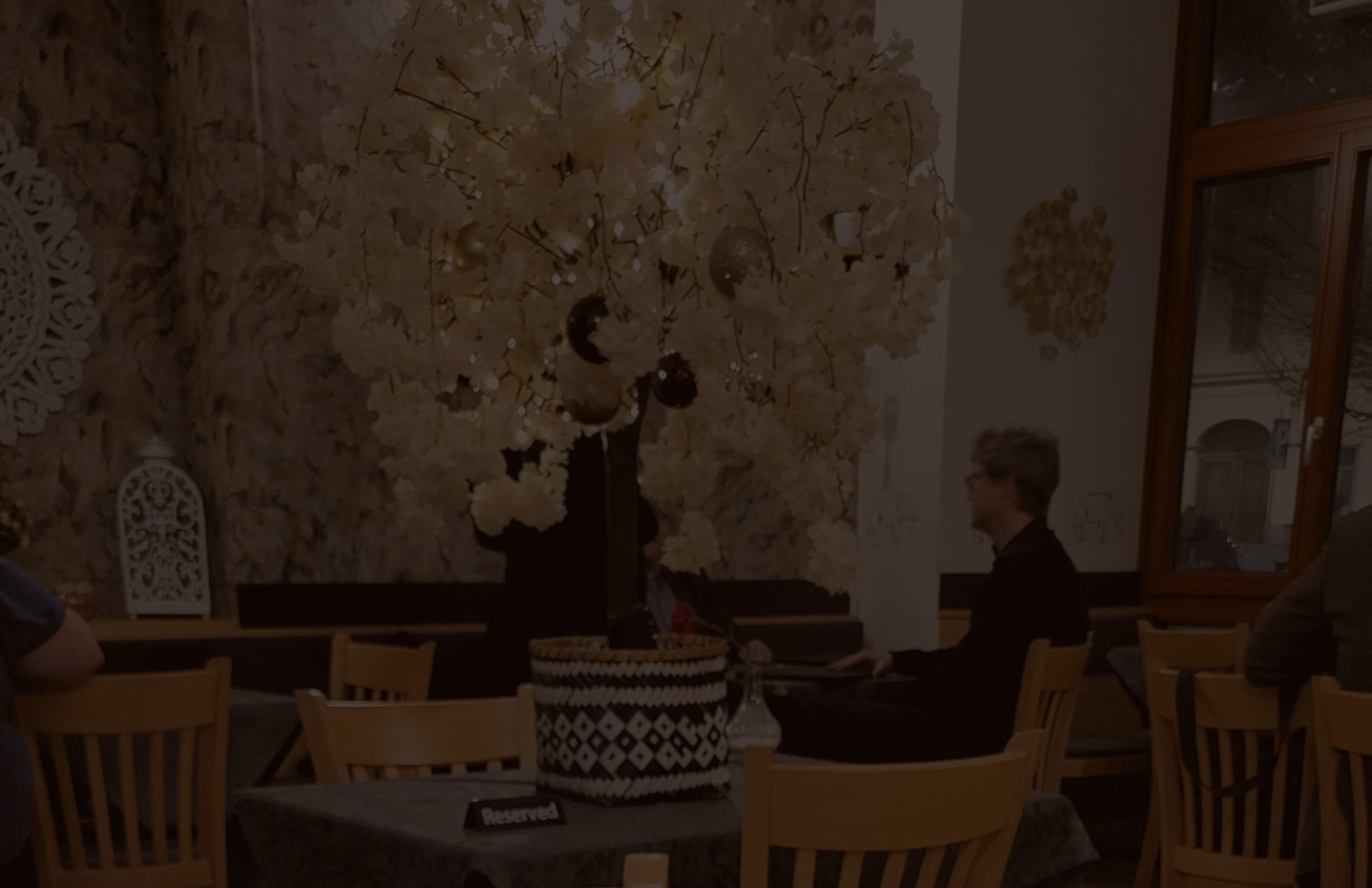 Exklusiv reservierter Tisch im Hathi indischen Restaurant mit hochwertiger Speisekarte in Schwarz und Gold. Die edle Tischgestaltung kombiniert dunkle Stoffe mit traditionellen indischen Mustern und feinen Details. Perfektes Gastronomie-Branding für luxuriöse Restaurants, umgesetzt von Unerwartet Branding und Design OG aus Graz, Österreich.