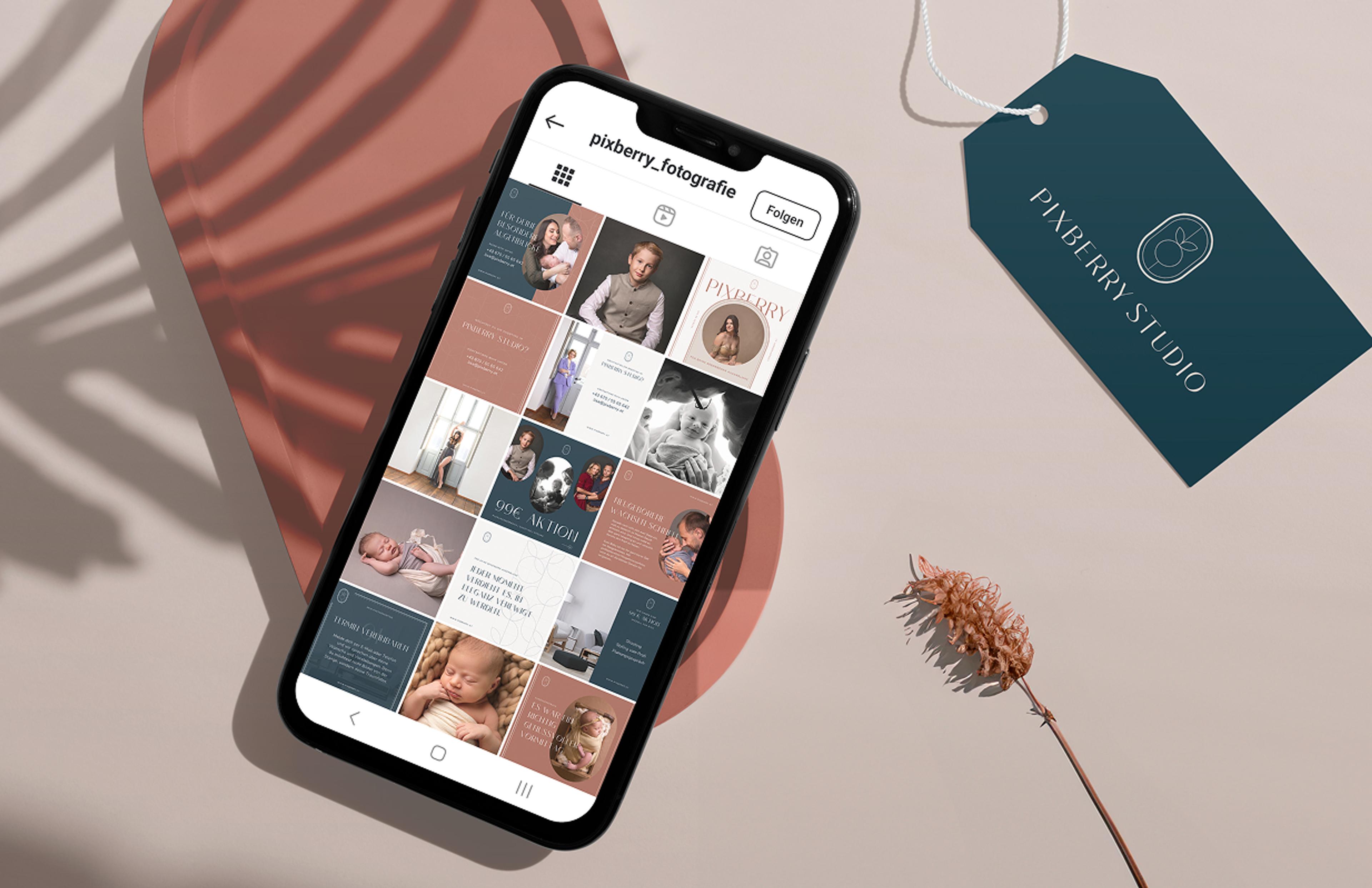 Smartphone mit Instagram-Feed von Pixberry, begleitet von Branding-Tag – Ein Handy mit dem Pixberry Instagram-Profil liegt auf einer rostroten Oberfläche, neben einem Branding-Tag in Petrol mit weißem Logo.