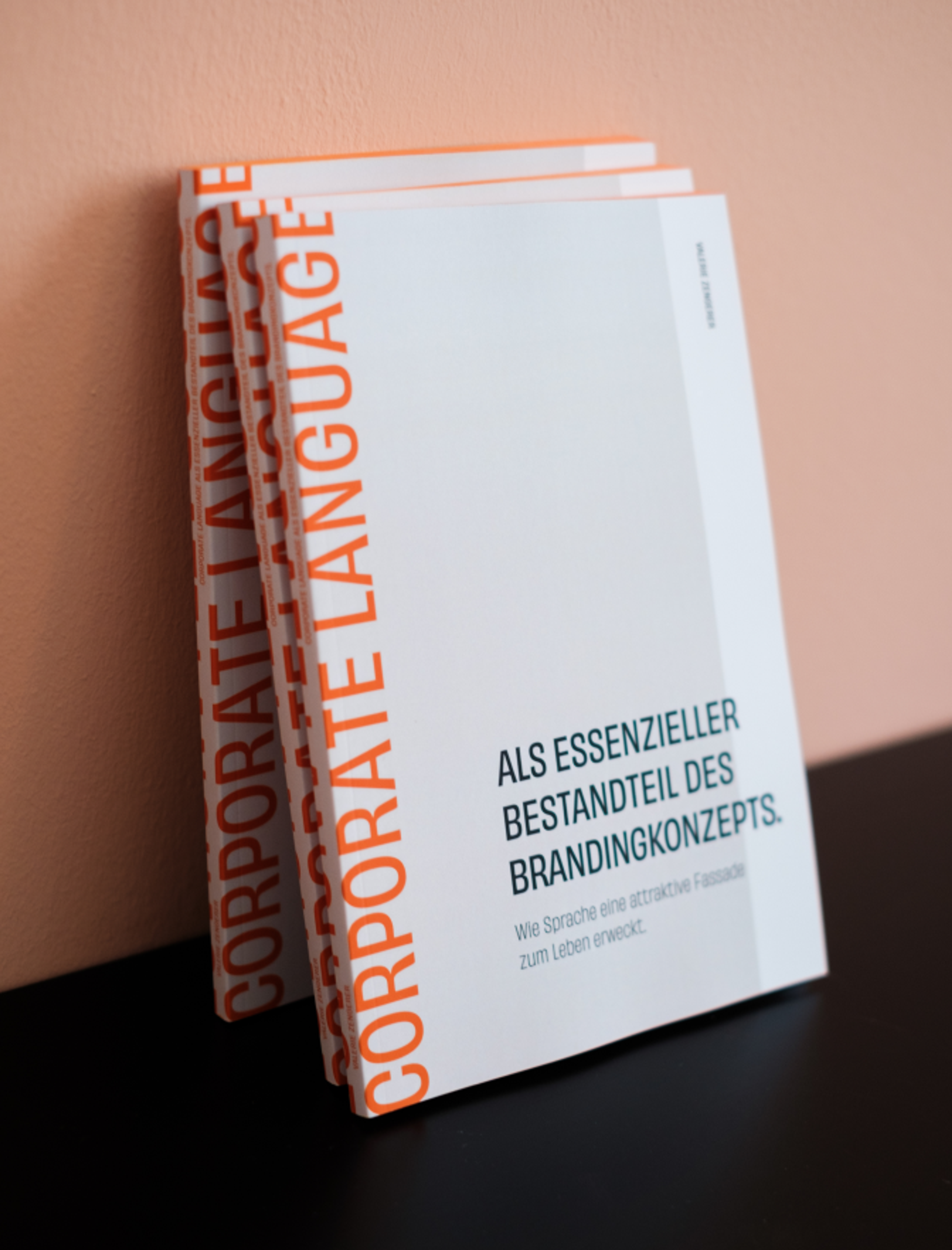 Mehrere Corporate Language Broschüren, gestaltet von Valerie Zengerer von Unerwartet Design, übereinander gestapelt, mit Fokus auf den Titel und die Seitenansicht.