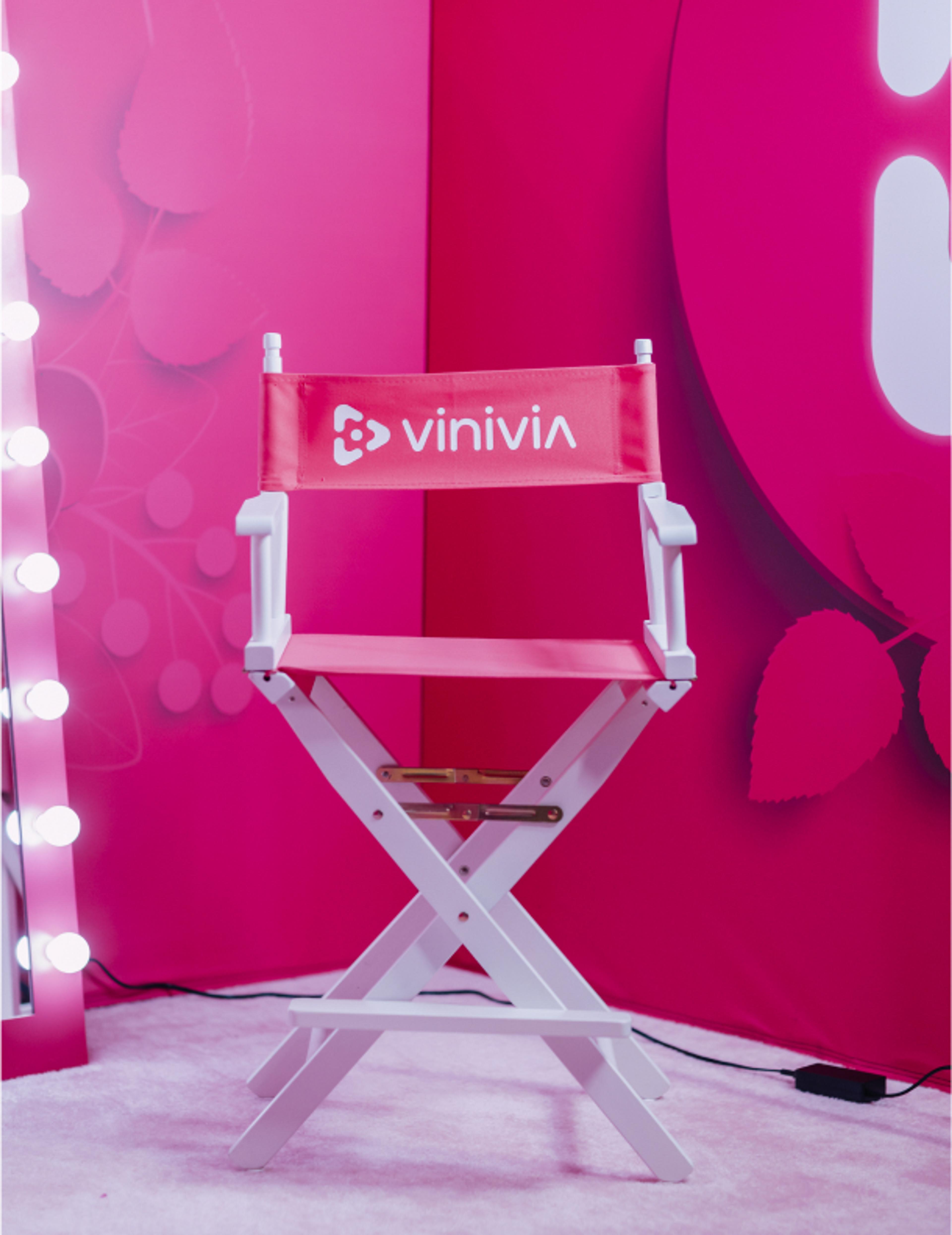 vinivia, bfa, jorgemezaphotos Vinivia Regiestuhl vor pinkem Hintergrund mit beleuchteten Spiegellichtern – auffallendes Branding für die Streaming-Plattform – Unerwartet Design