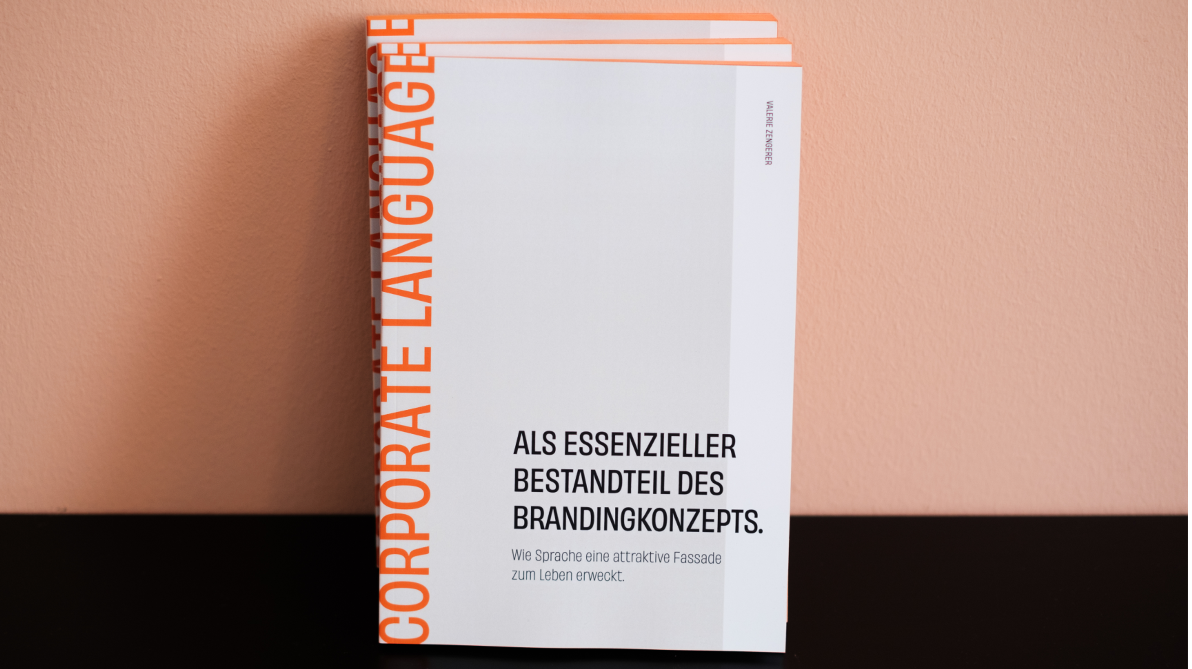 Mehrere Corporate Language Broschüren, gestaltet von Valerie Zengerer von Unerwartet Design, übereinander gestapelt, mit Fokus auf den Titel und die Vorderansicht.