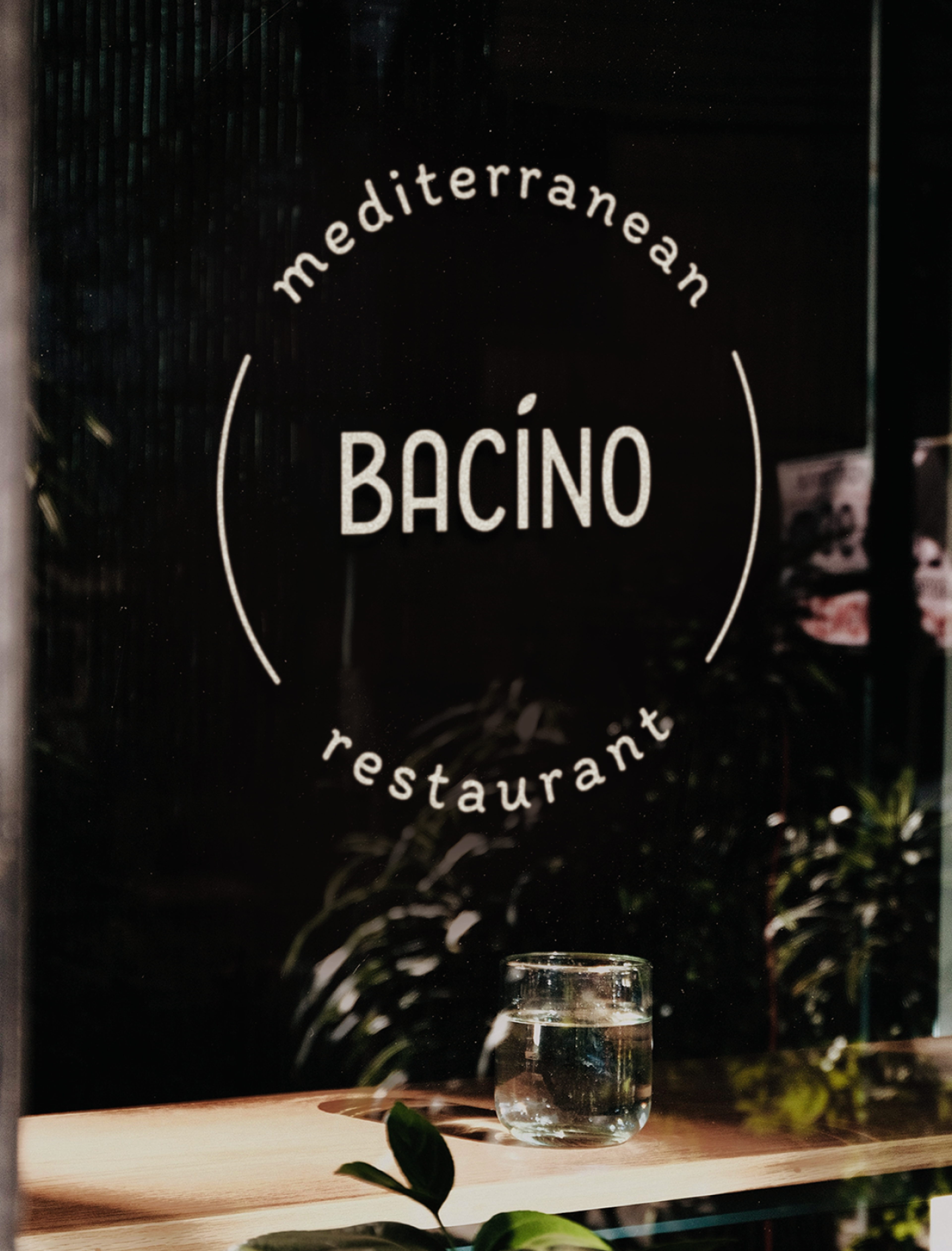 Bacino-Logo und Schriftzug auf einem Schaufenster, umgeben von mediterraner Dekoration.