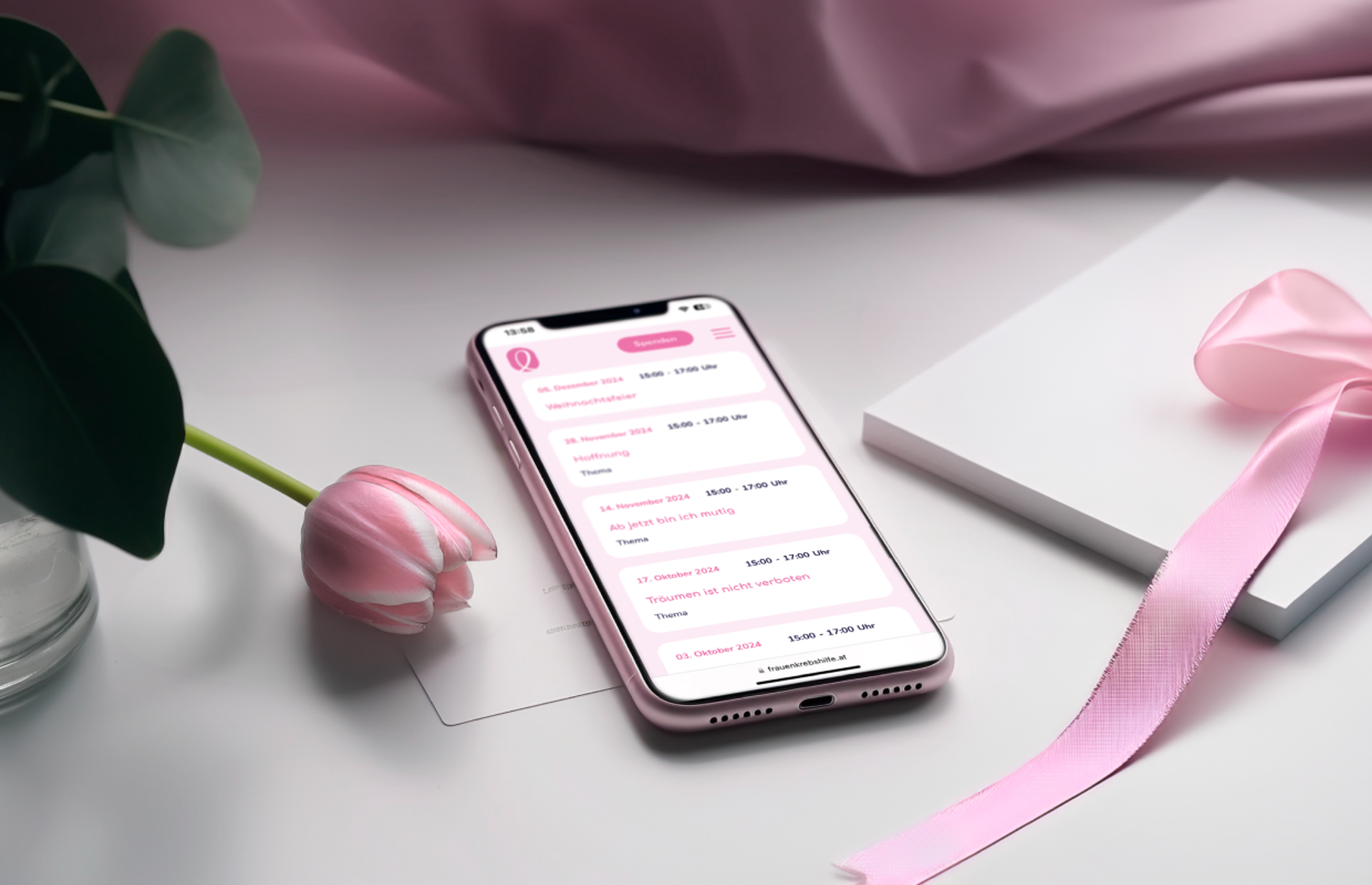 Smartphone mit der Frauen- und Brustkrebshilfe Steiermark Website, gestaltet von Unerwartet Design. Eventliste mit pinken Designelementen und eleganter Ästhetik - Unerwartet Design.
