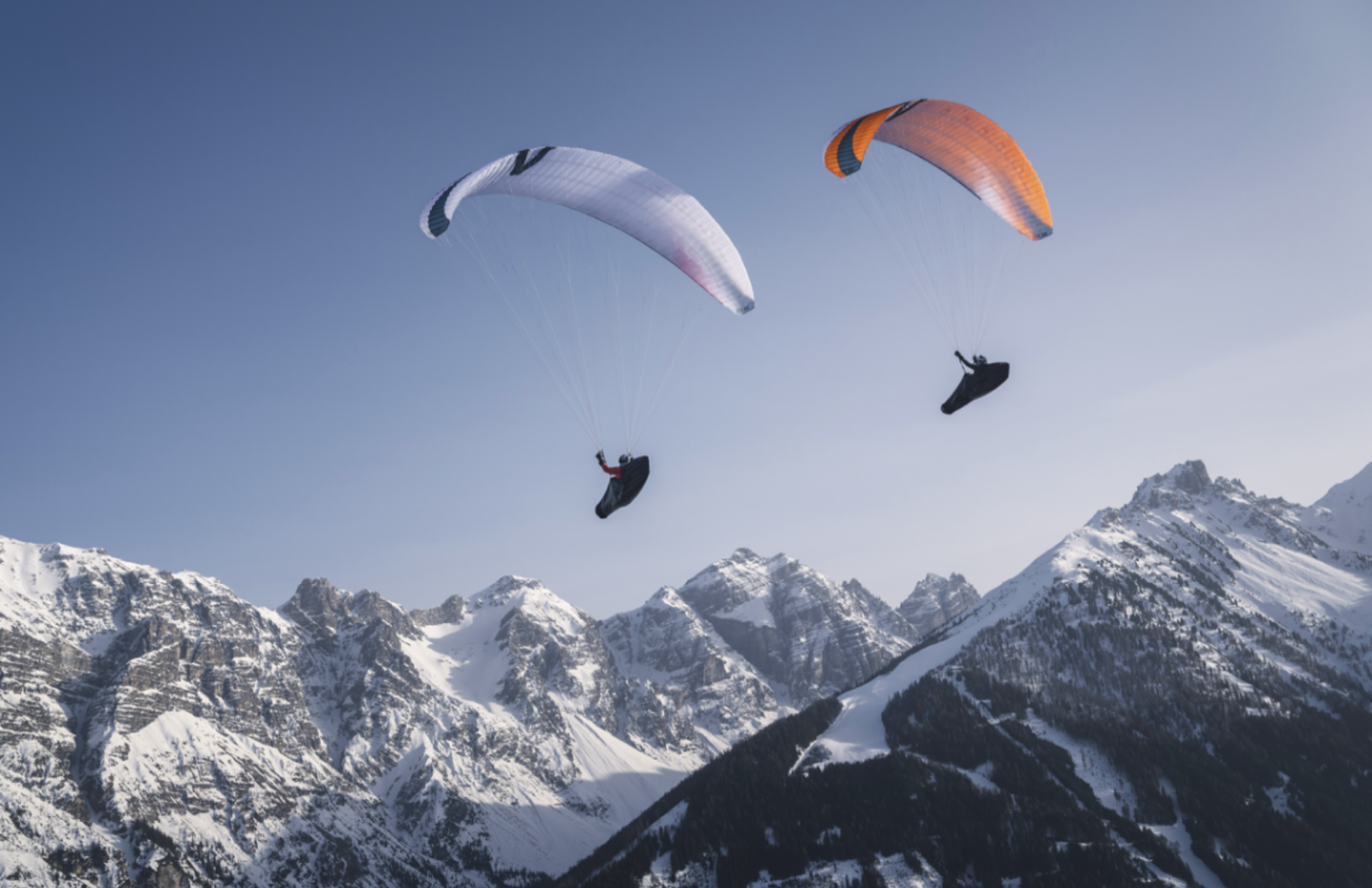 Paragliding über verschneiten Bergen, aufgenommen für die Kampagne von Luftikus, unterstützt durch Unerwartet Design.