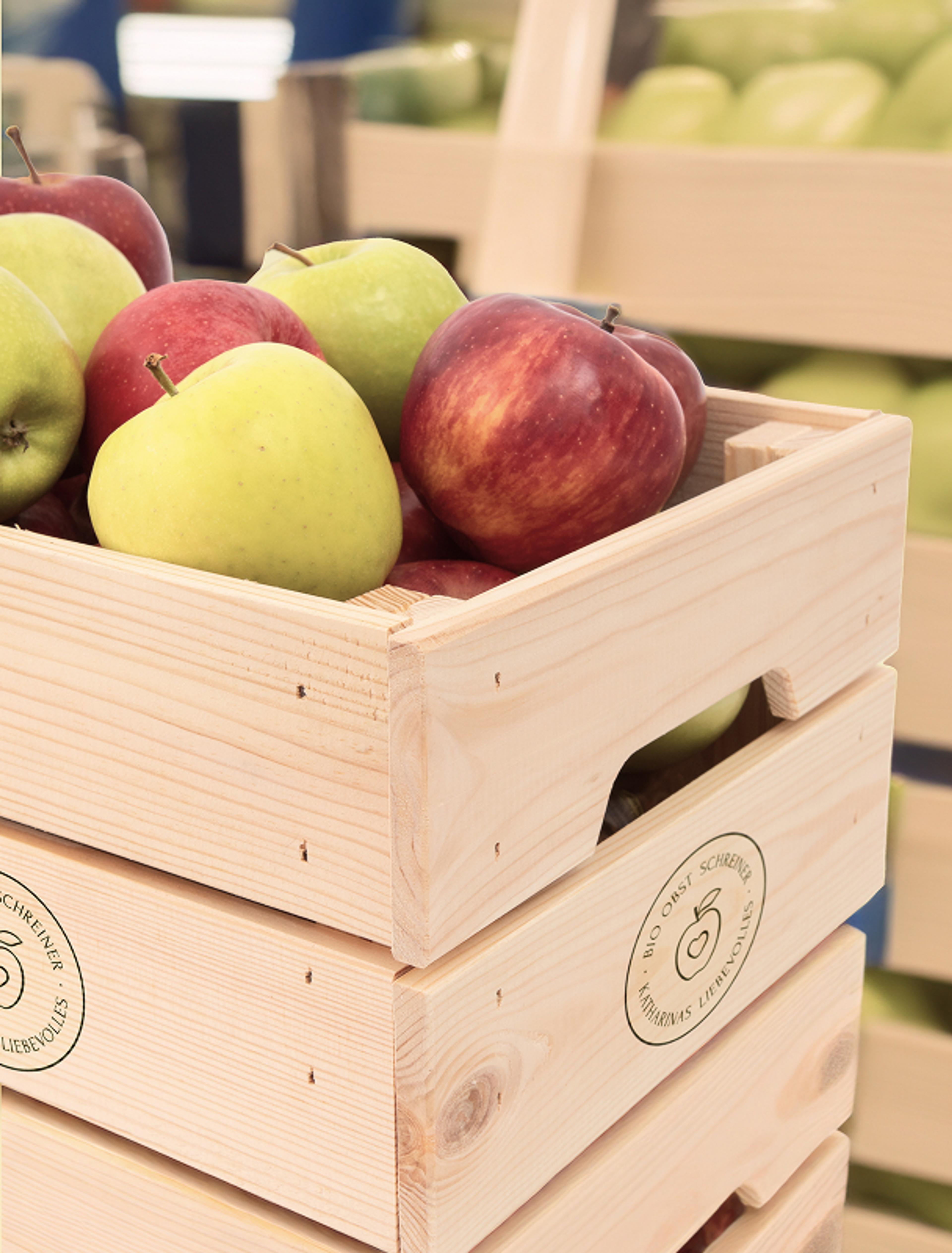 Holzkiste mit Bioobst Logo veredelt und gefüllt mit Äpfeln.