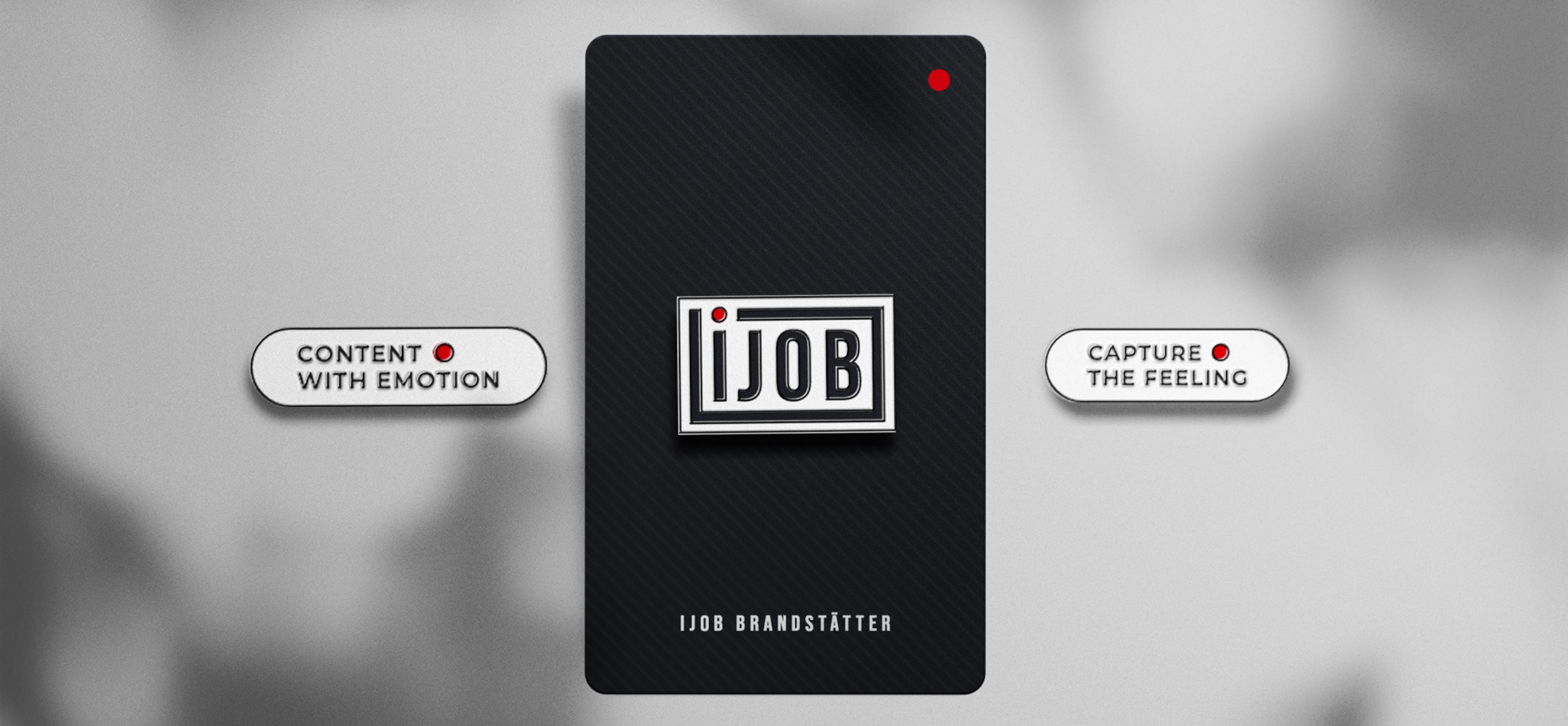 Ijob-Markenkarte mit Slogans – Eine schwarze Karte mit diagonalem Muster zeigt das Ijob-Logo als erhabenes Metall-Emblem. Links und rechts daneben befinden sich die Markenbotschaften „Content with Emotion“ und „Capture the Feeling“ mit roten Punkt-Akzenten.