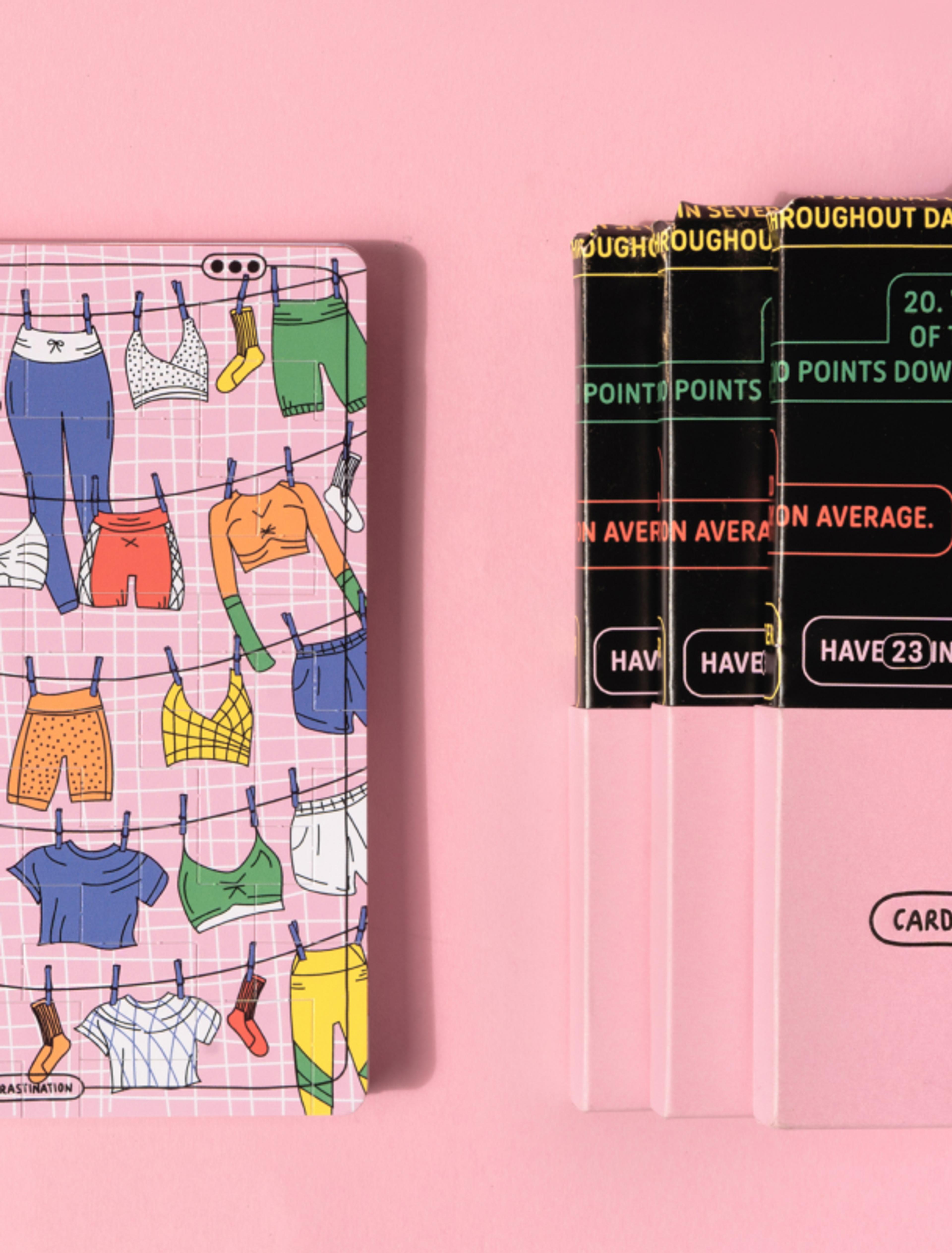 Miriam Leitinger Geschlossene Box des Kartensets „Cards for Procrastination“ mit buntem Kleidungsmuster auf rosa Hintergrund. Daneben transparente Karten mit Textfragmenten in Schwarz und Gelb.