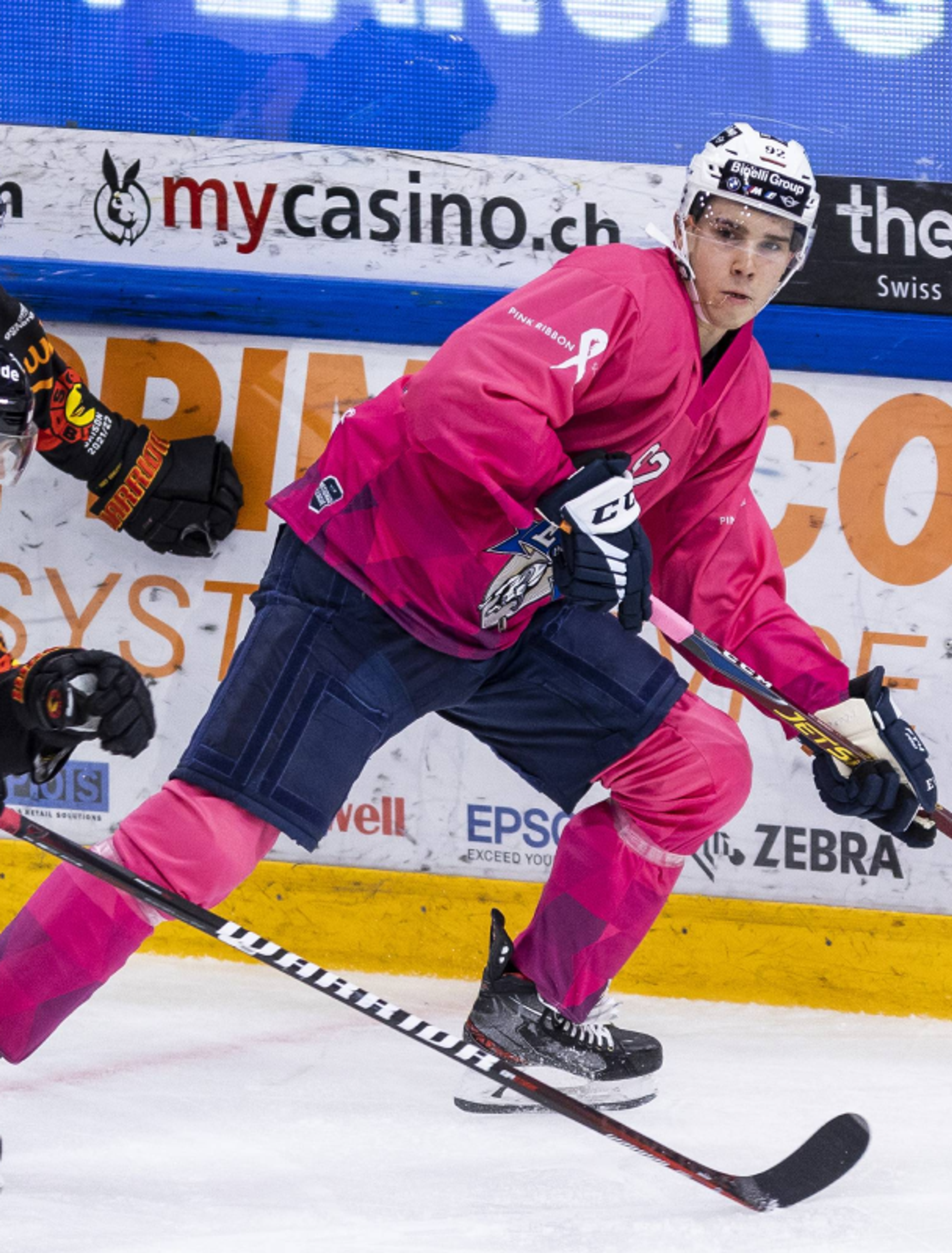 Keystone-sda, pilatustoday.ch Eishockeyspieler des EVZ-Teams in pinkfarbenem Trikot, gestaltet von Vinivia, während eines Spiels in der Schweizer Eishockeyliga – Unerwartet Design