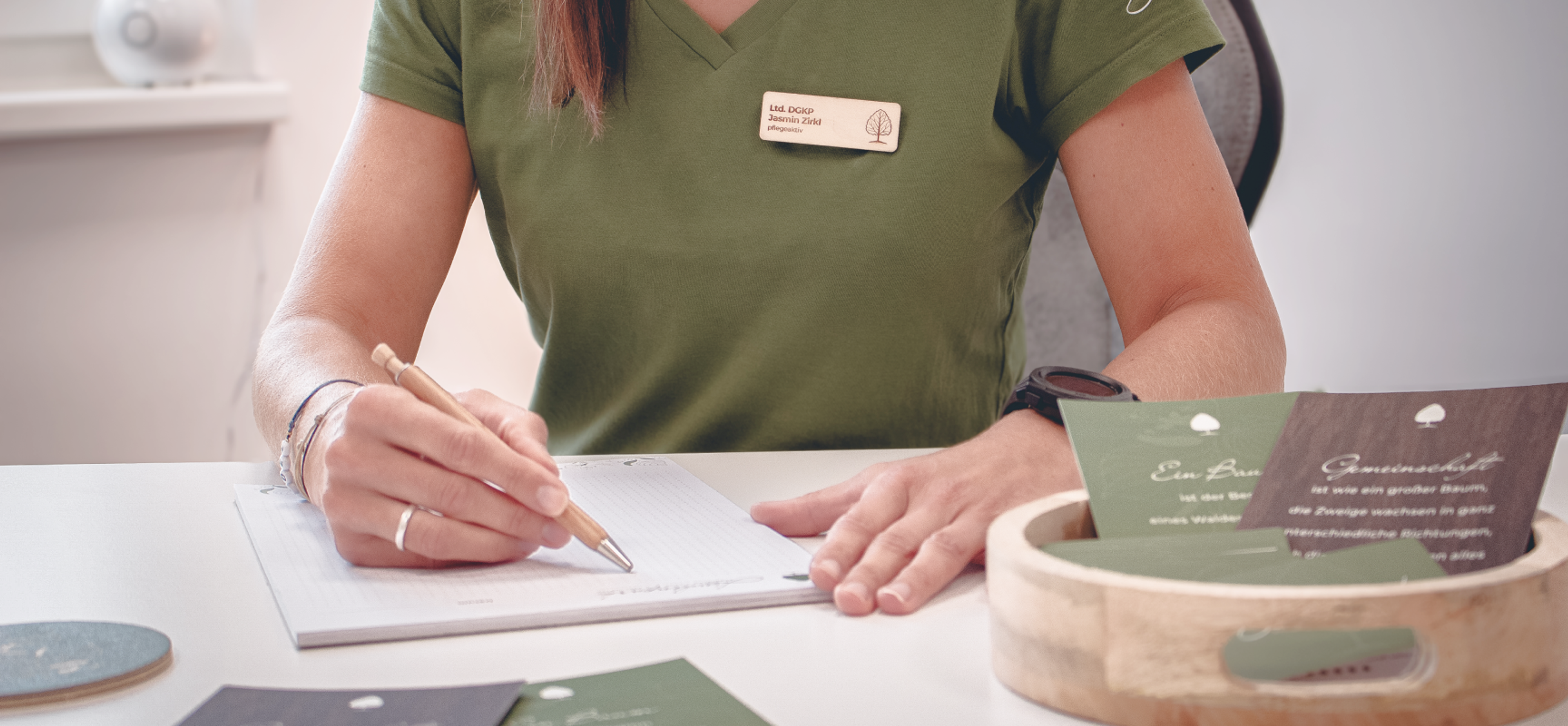 Logo & Grundkonzept BUCHER BRAND MARKETING e.U. Die Managerin des Lindenparks (Jasmin Zirkl) mit Namensschild, Holzkugelschreiber und Notizblock, gestaltet von Unerwartet Design